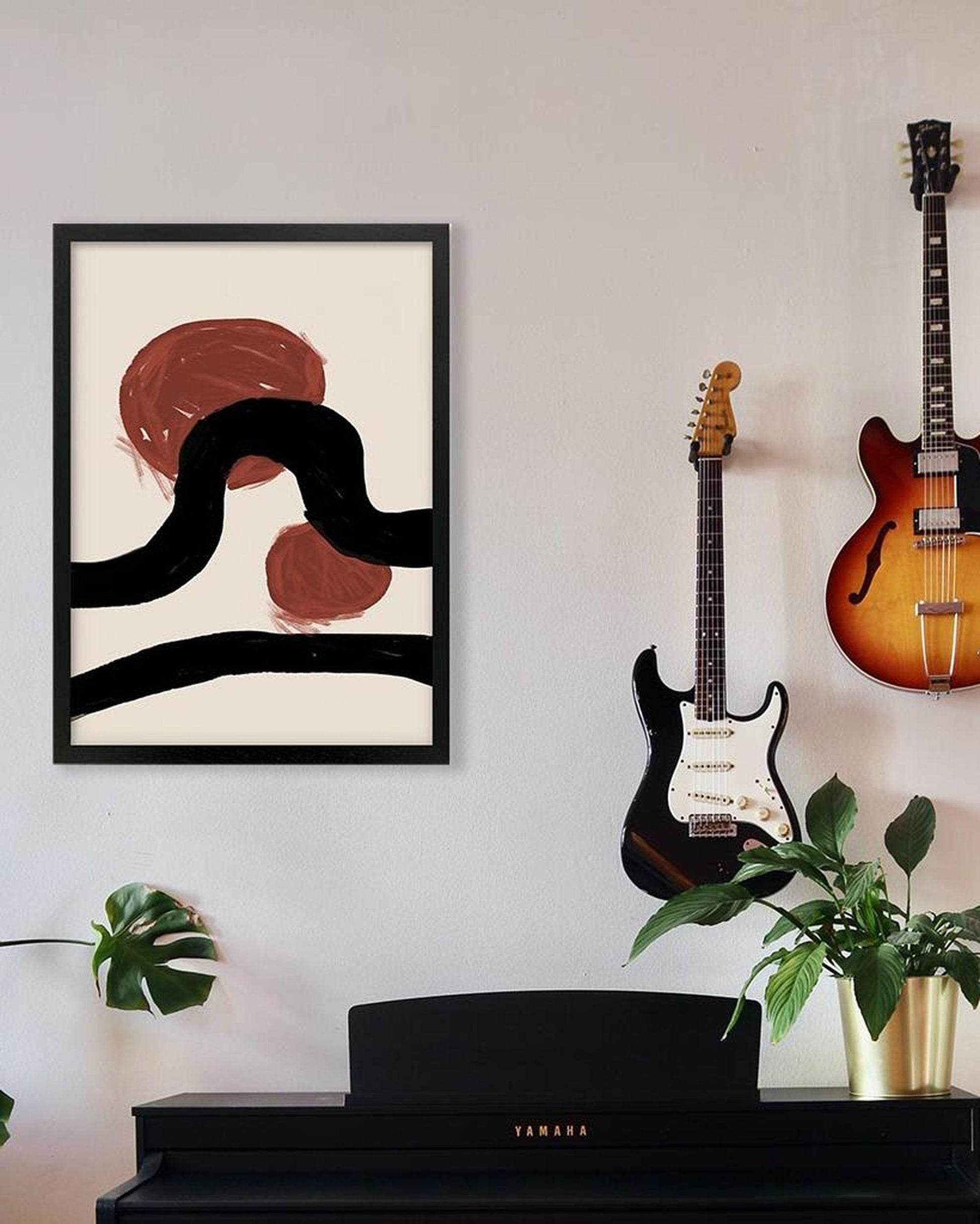 Abstract art on the wall with two guitars and a piano below.