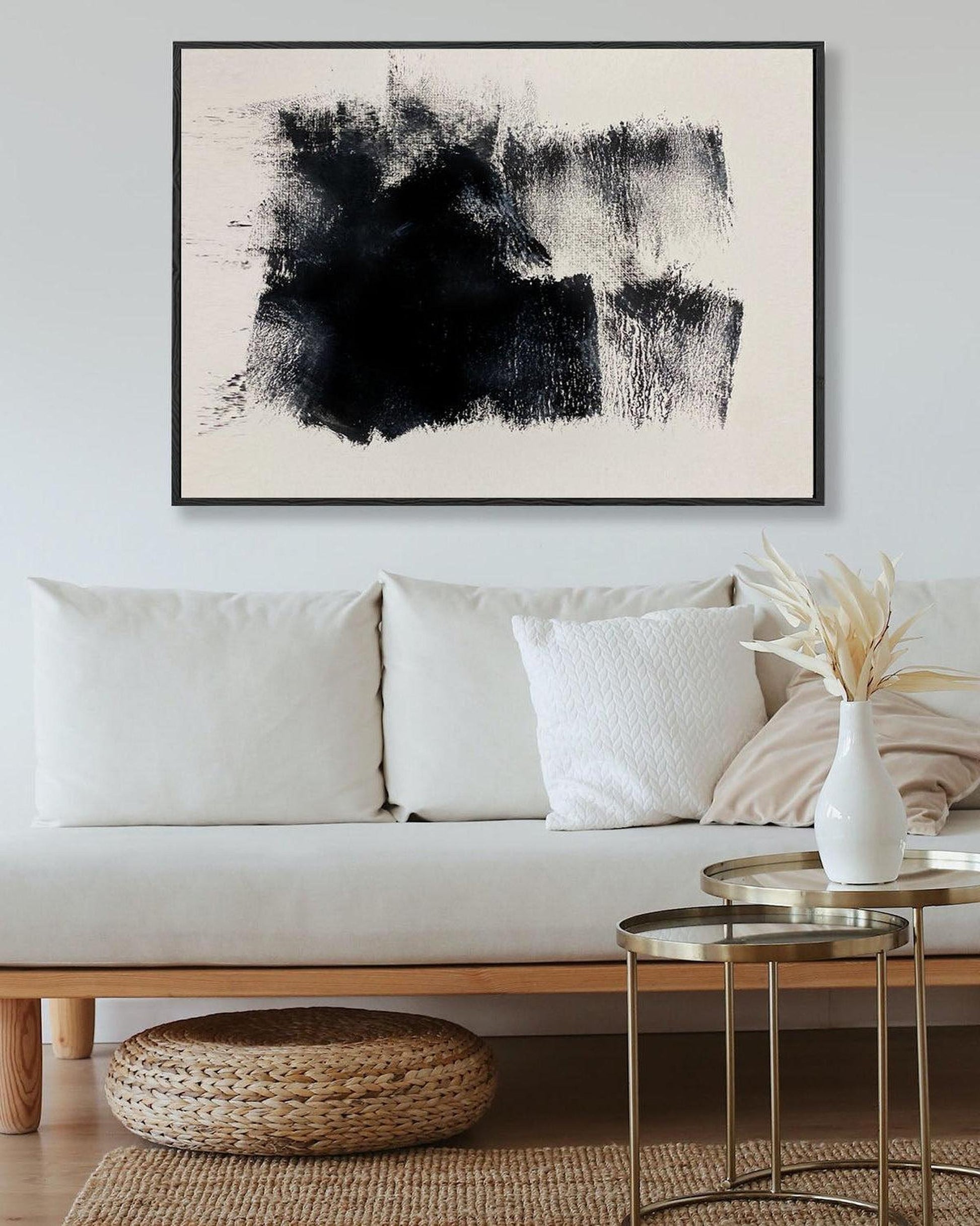 Modern living room with a white sofa, abstract art, and decorative items.