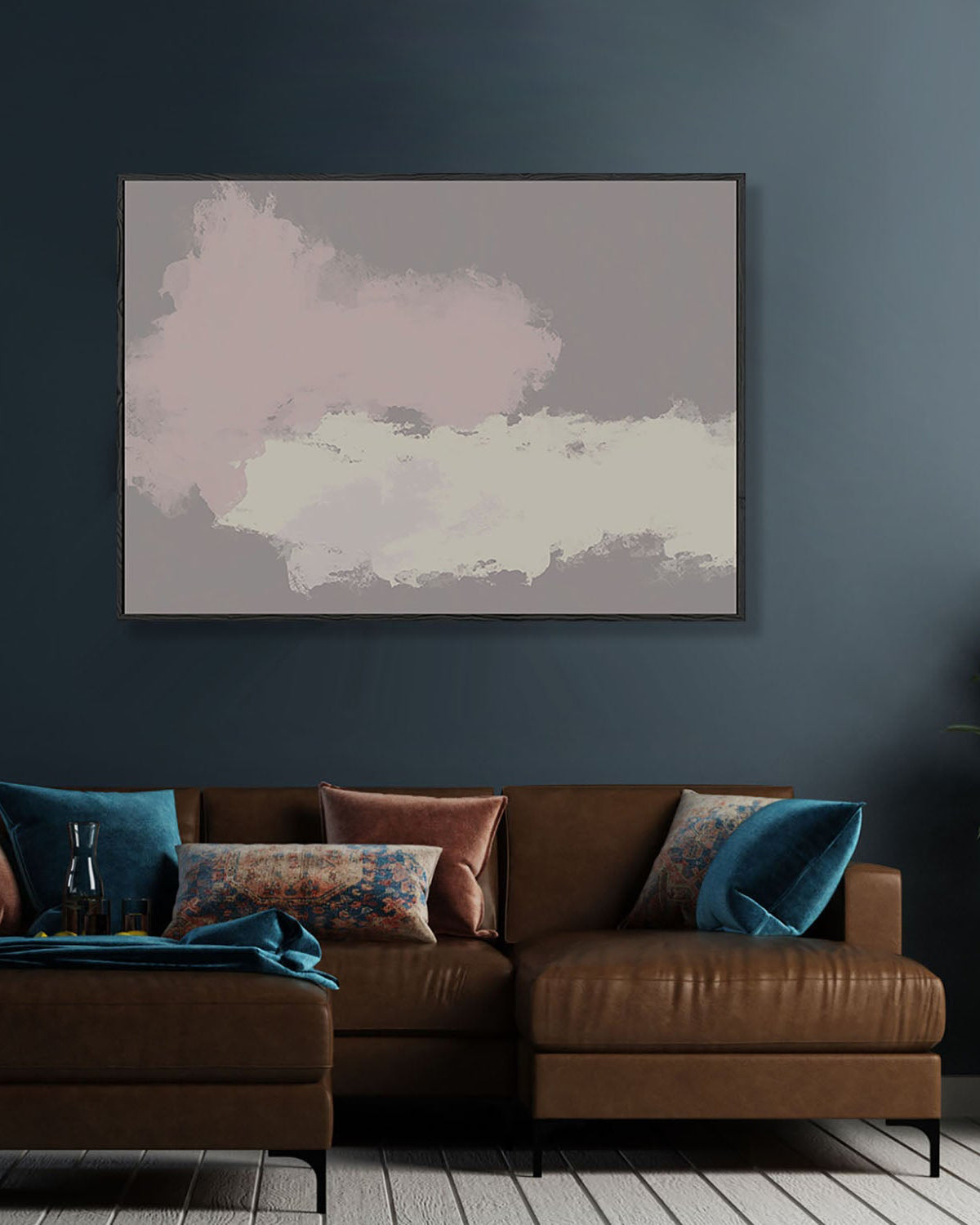 Abstract art print on a dark wall above a brown leather sofa with colorful pillows.