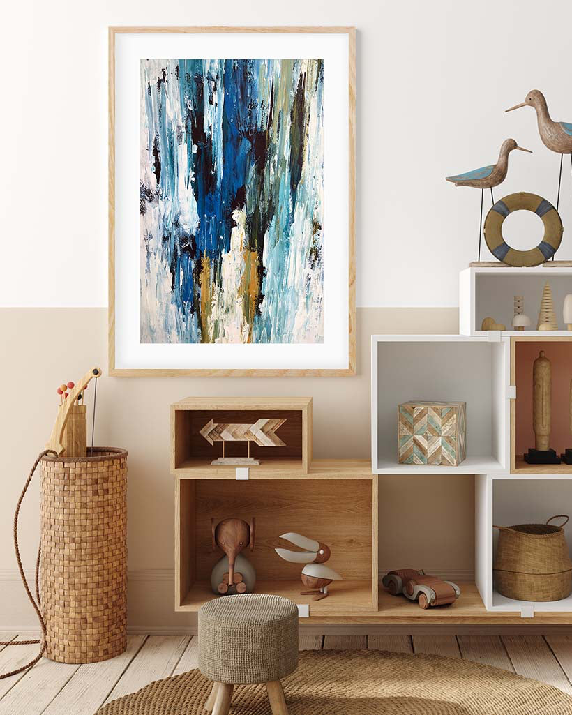 Abstract art print in a wooden frame on a wall above a shelf with decorative items.