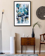 Modern living room with abstract art, wooden cabinet, and decorative items.