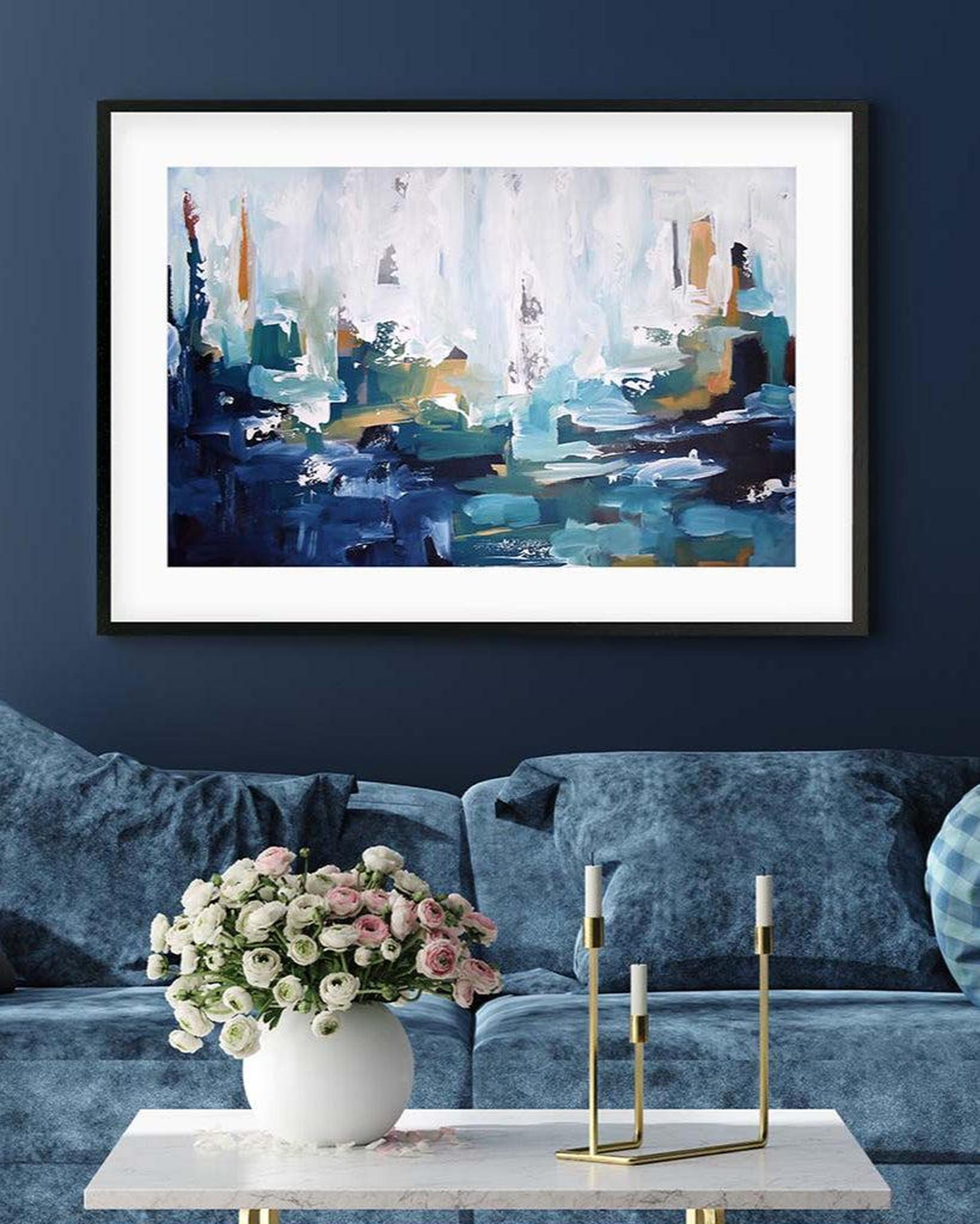 Abstract painting in a modern living room with a blue sofa and decorative items.