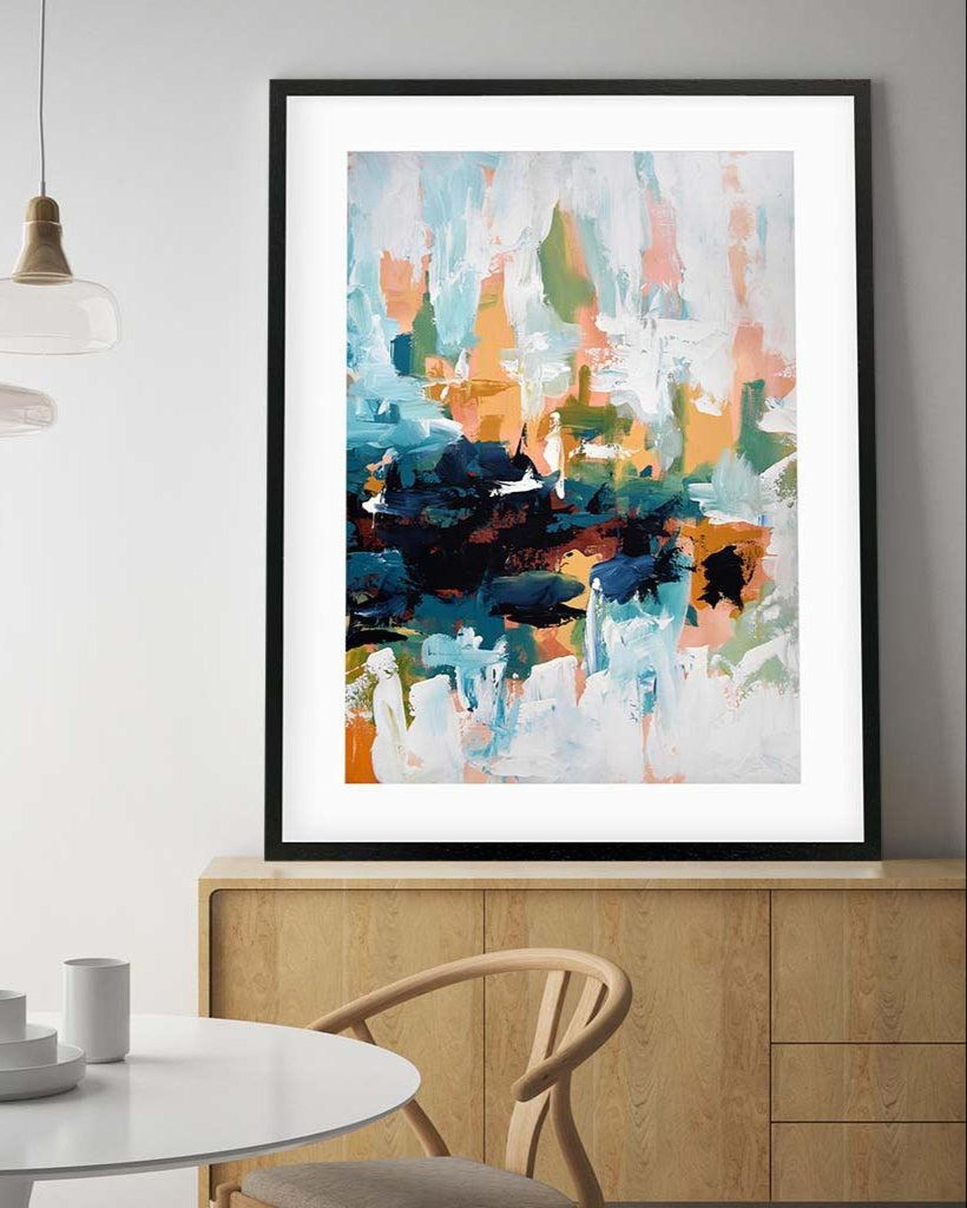 Abstract art print on a wall above a dining table with modern decor.