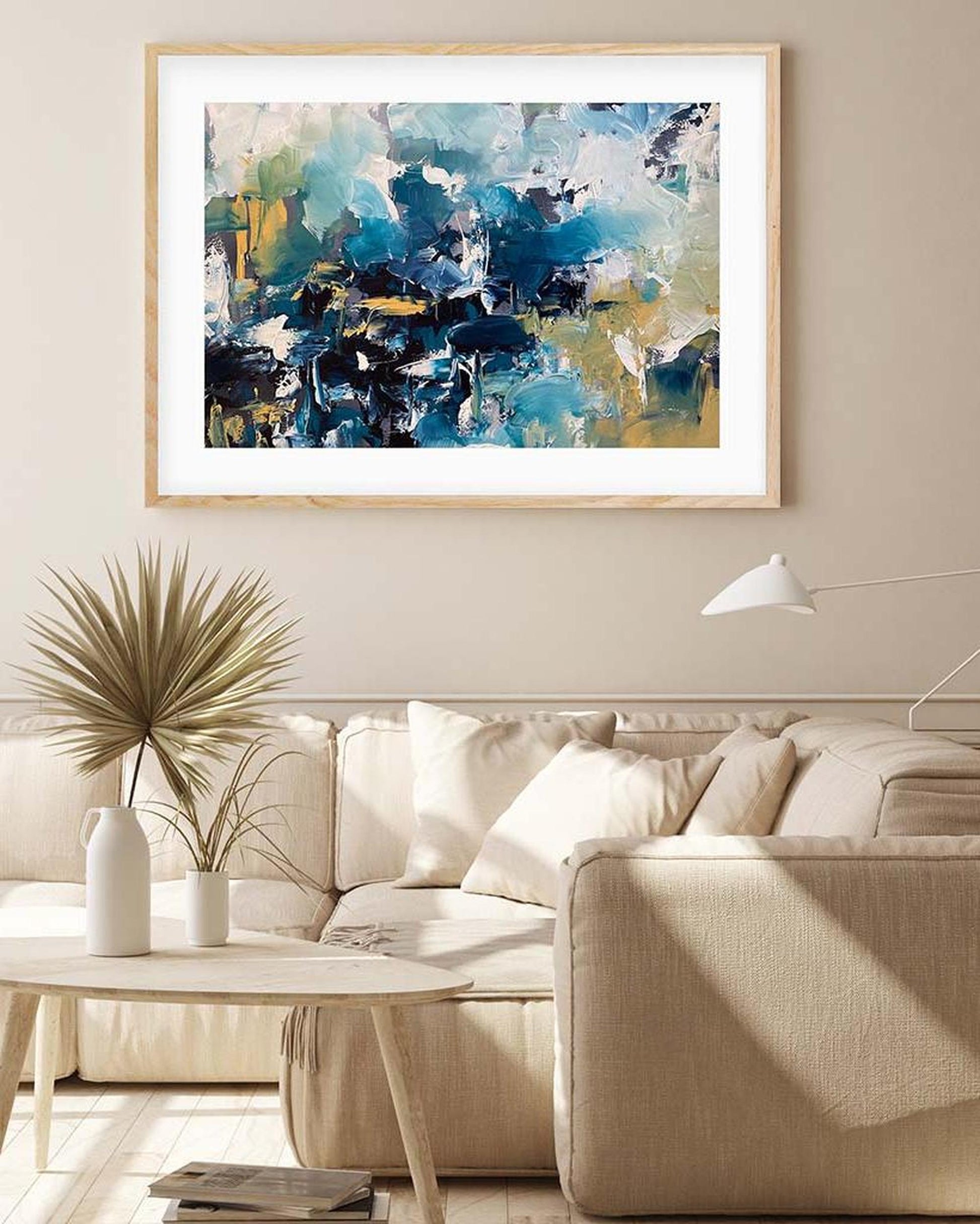 Abstract painting in a living room with a beige sofa and decorative items.