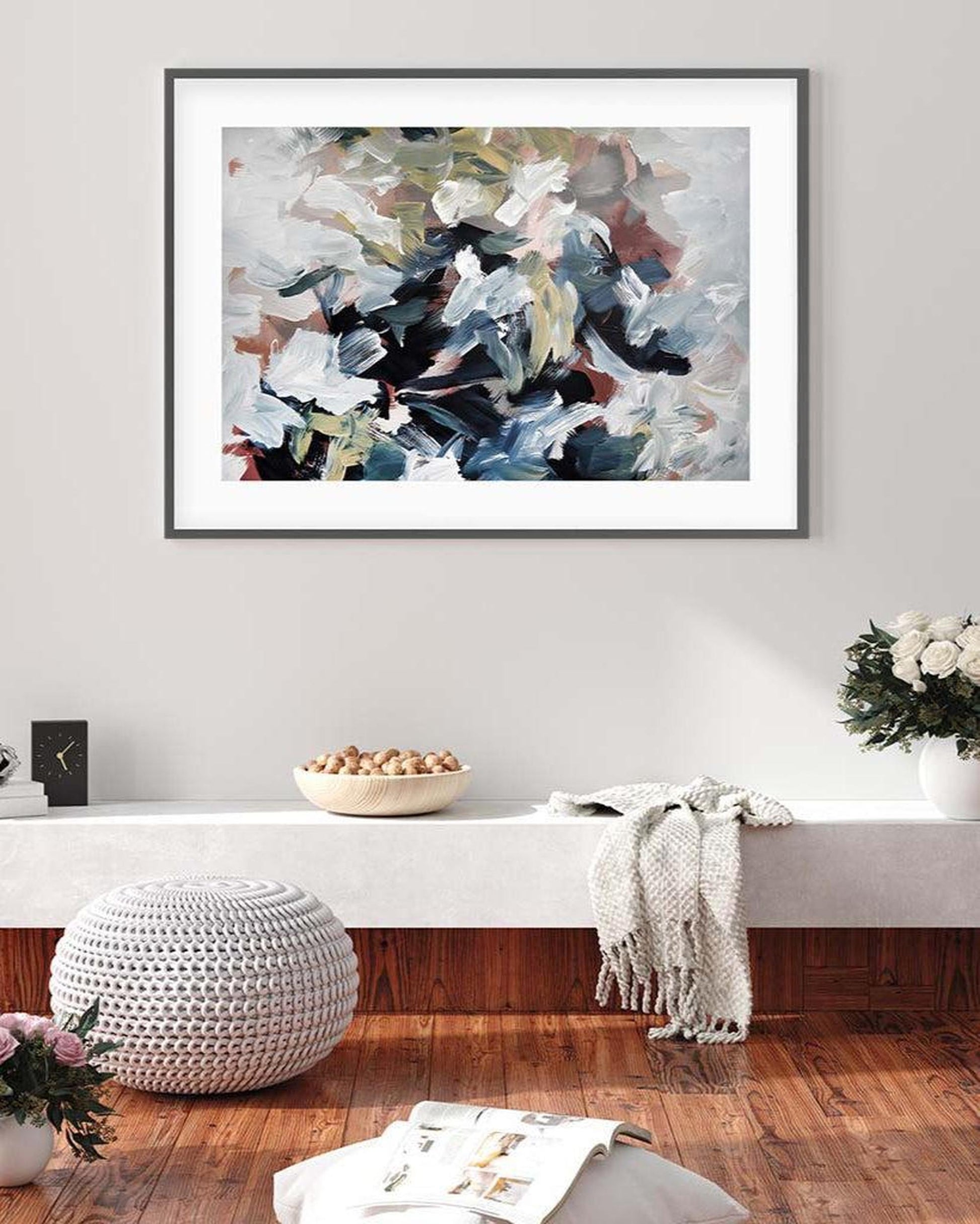Abstract painting on a wall in a living room with decor elements.