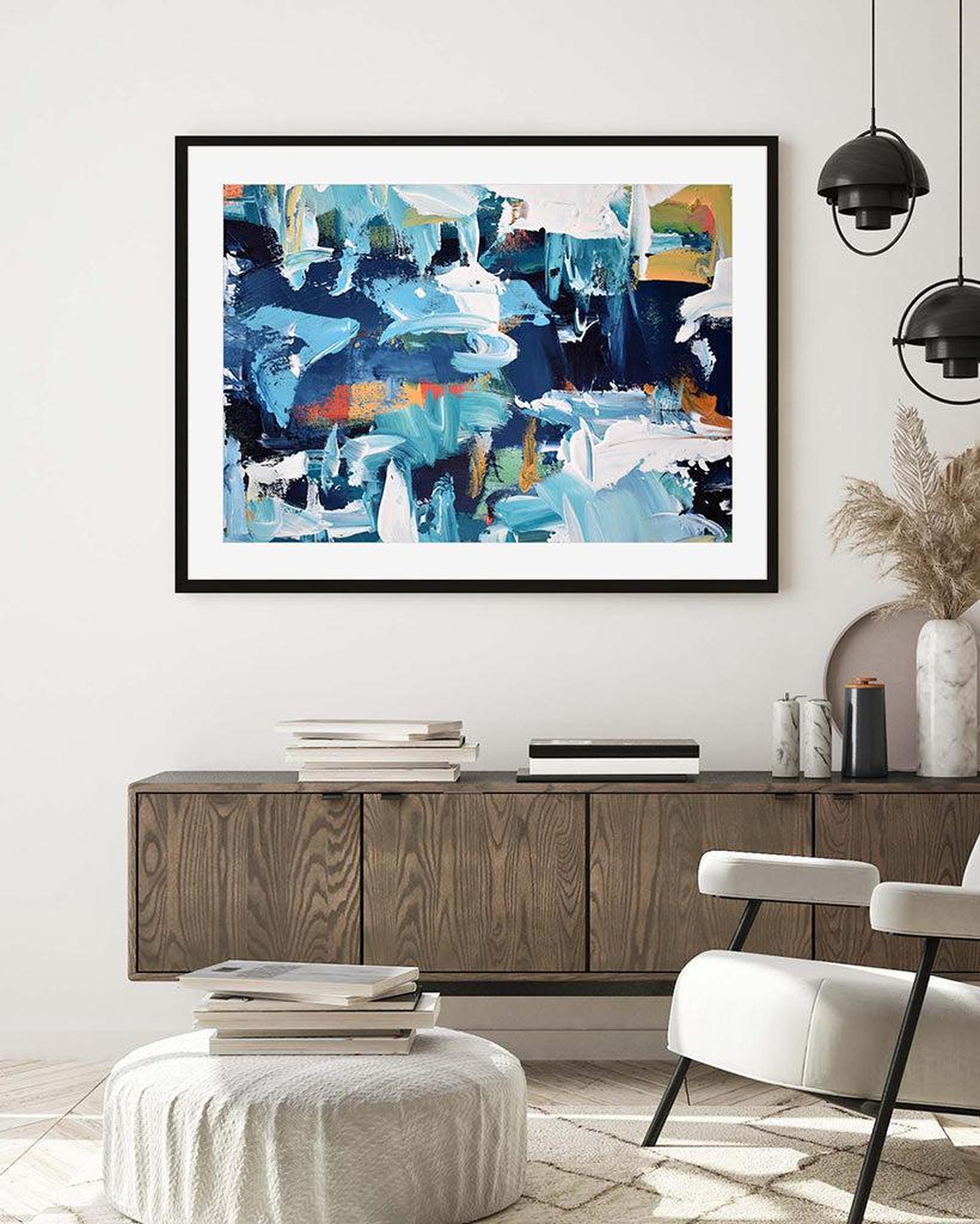 Abstract painting in a modern living room with a wooden cabinet and white chair.