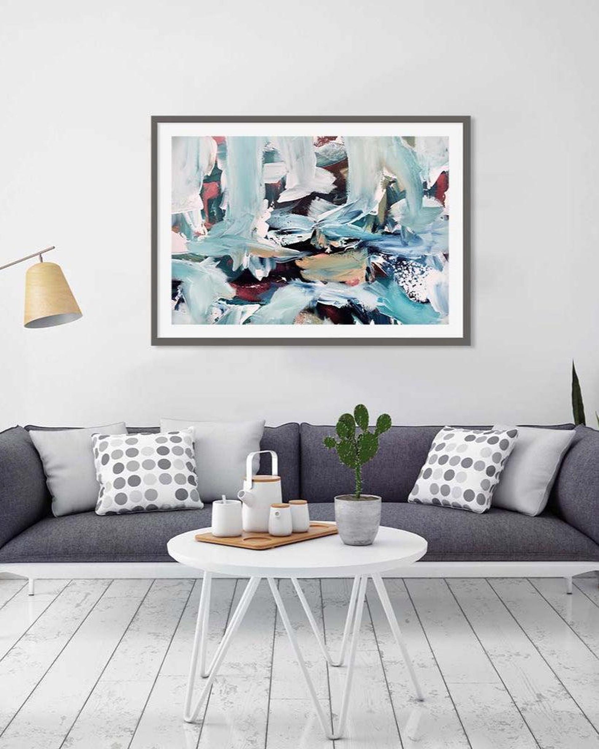 Framed abstract art piece on a wall above a sofa in a living room.