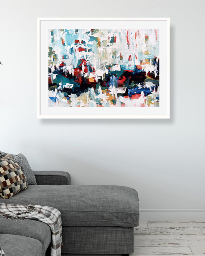 Abstract art print on a wall above a gray sofa