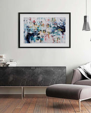 Abstract painting on a wall above a dark piece of furniture in a modern living room.