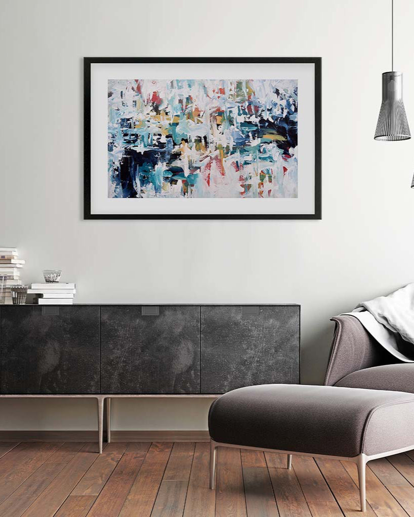 Abstract painting on a wall above a dark piece of furniture in a modern living room.