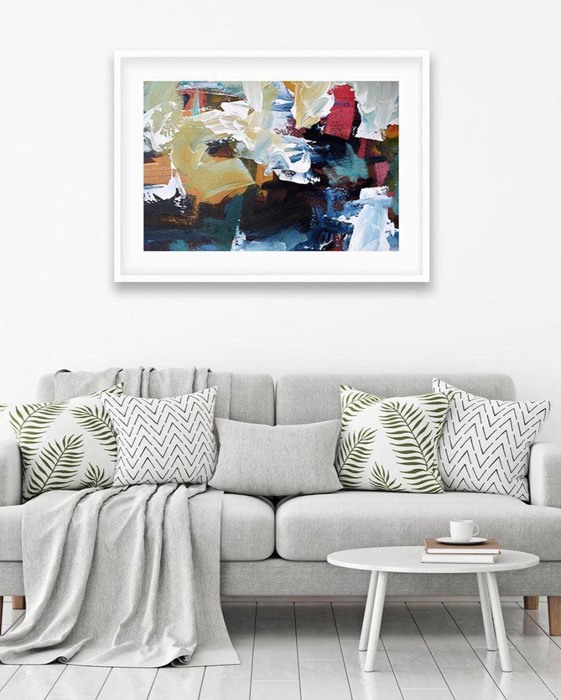 Gray sofa with decorative pillows and a colorful abstract painting on the wall.