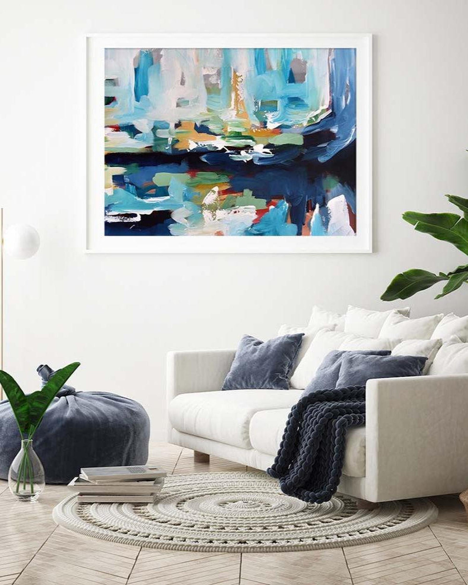 Living room with a white sofa, abstract art on the wall, and decorative elements.