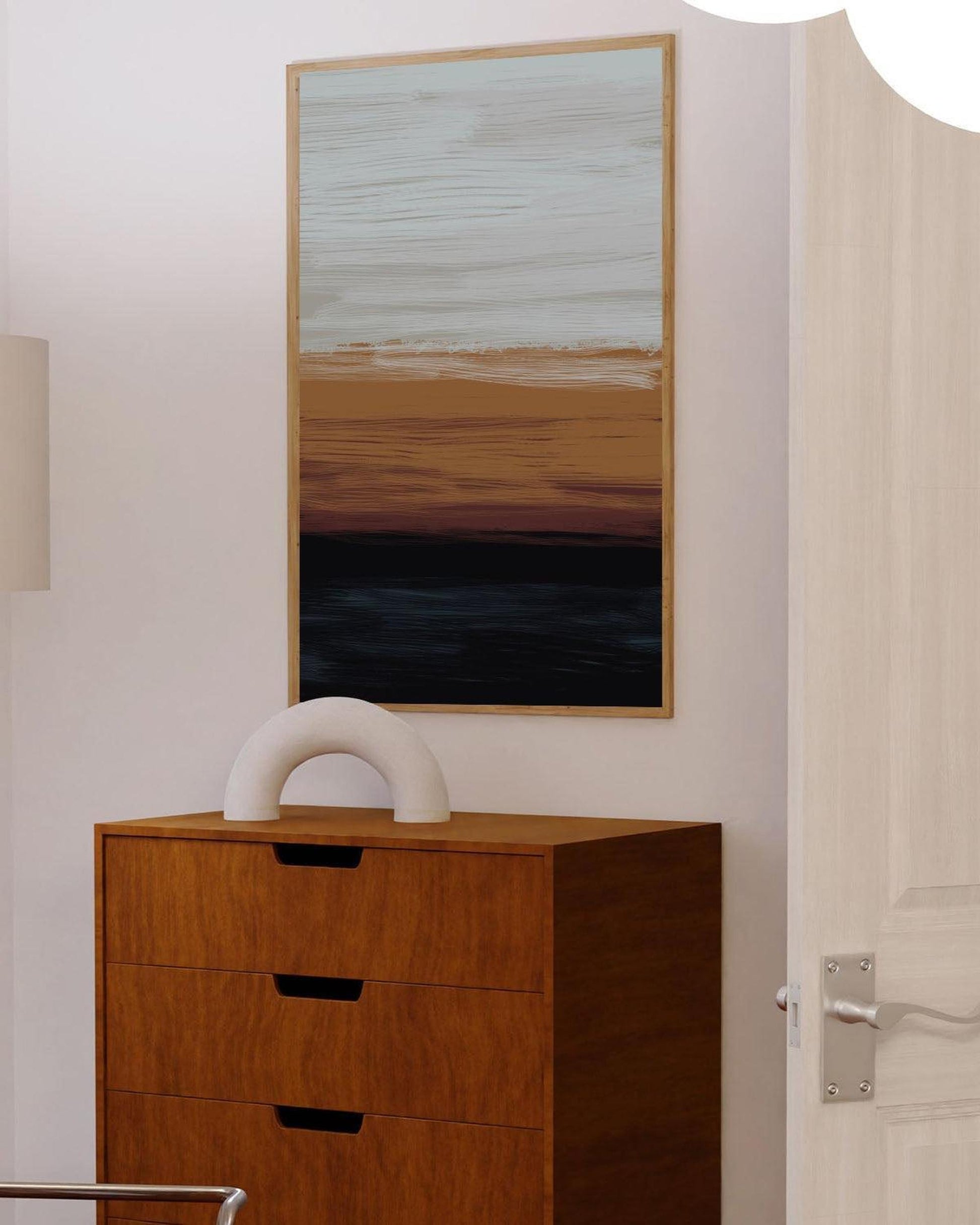 Wooden dresser with a white sculpture next to a abstract painting on a wall.
