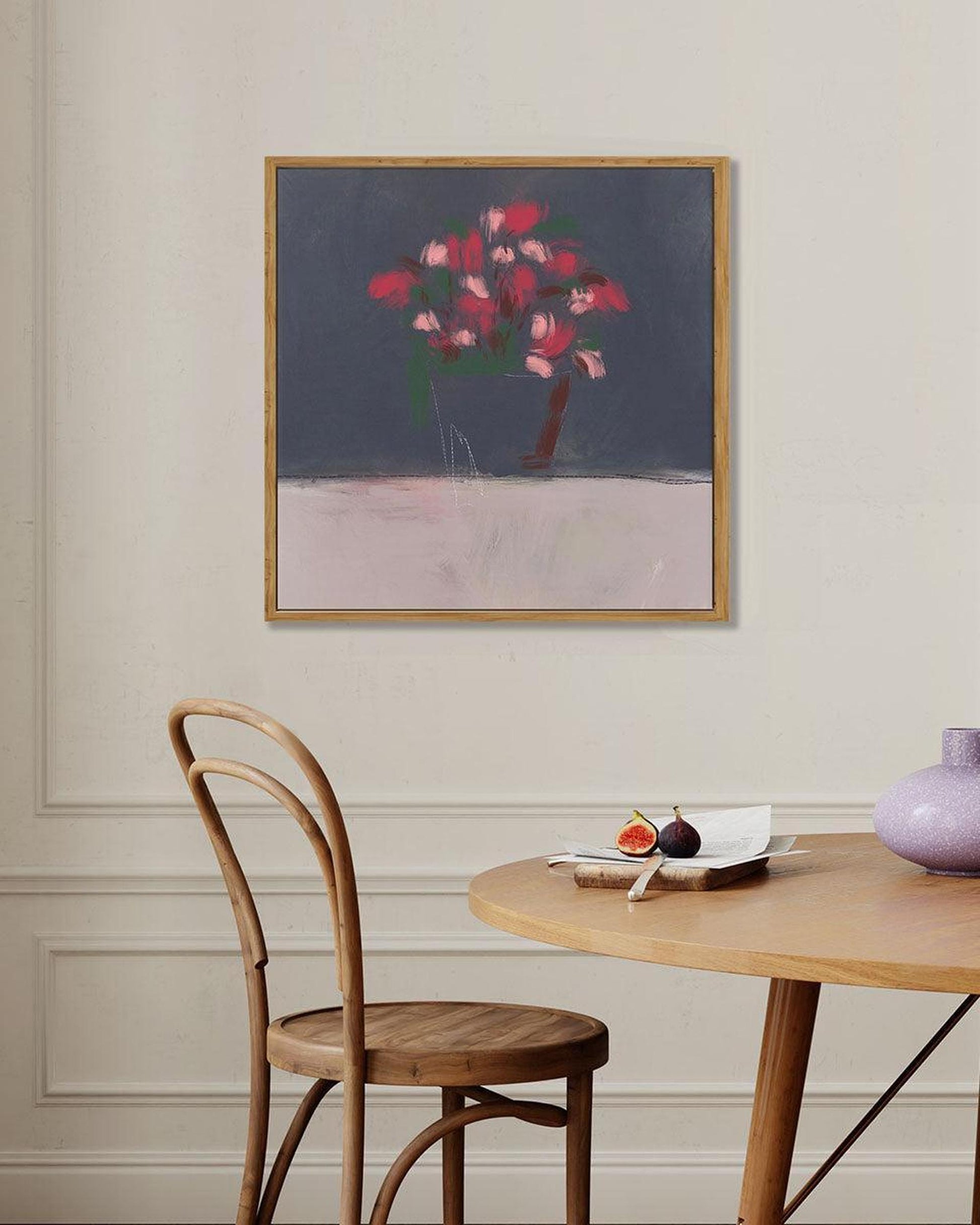 Dining room with a wooden table, chair, and abstract painting on the wall.