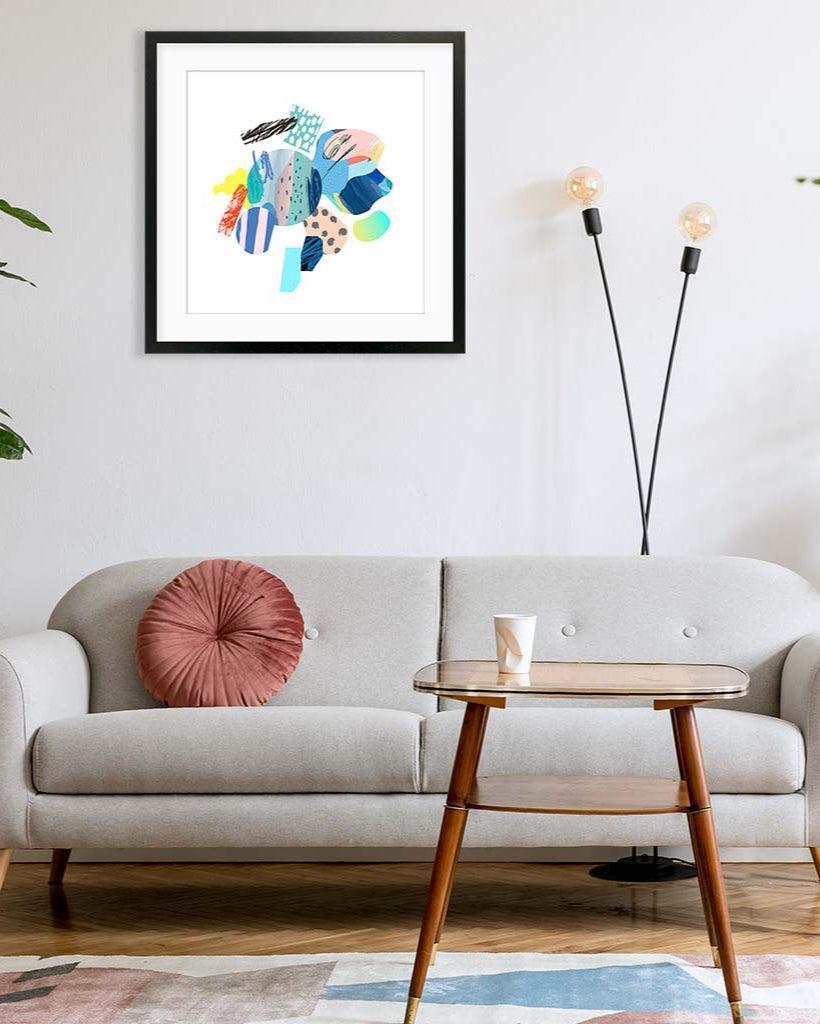 Colorful abstract art piece on a wall above a sofa in a living room.