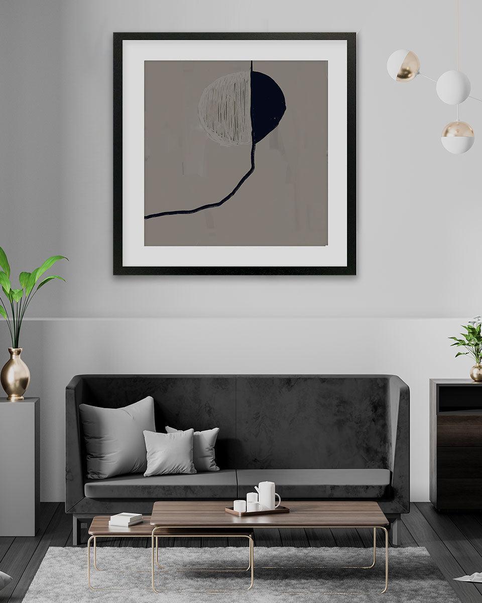 Modern living room with a black sofa, wooden coffee table, and abstract art on the wall.