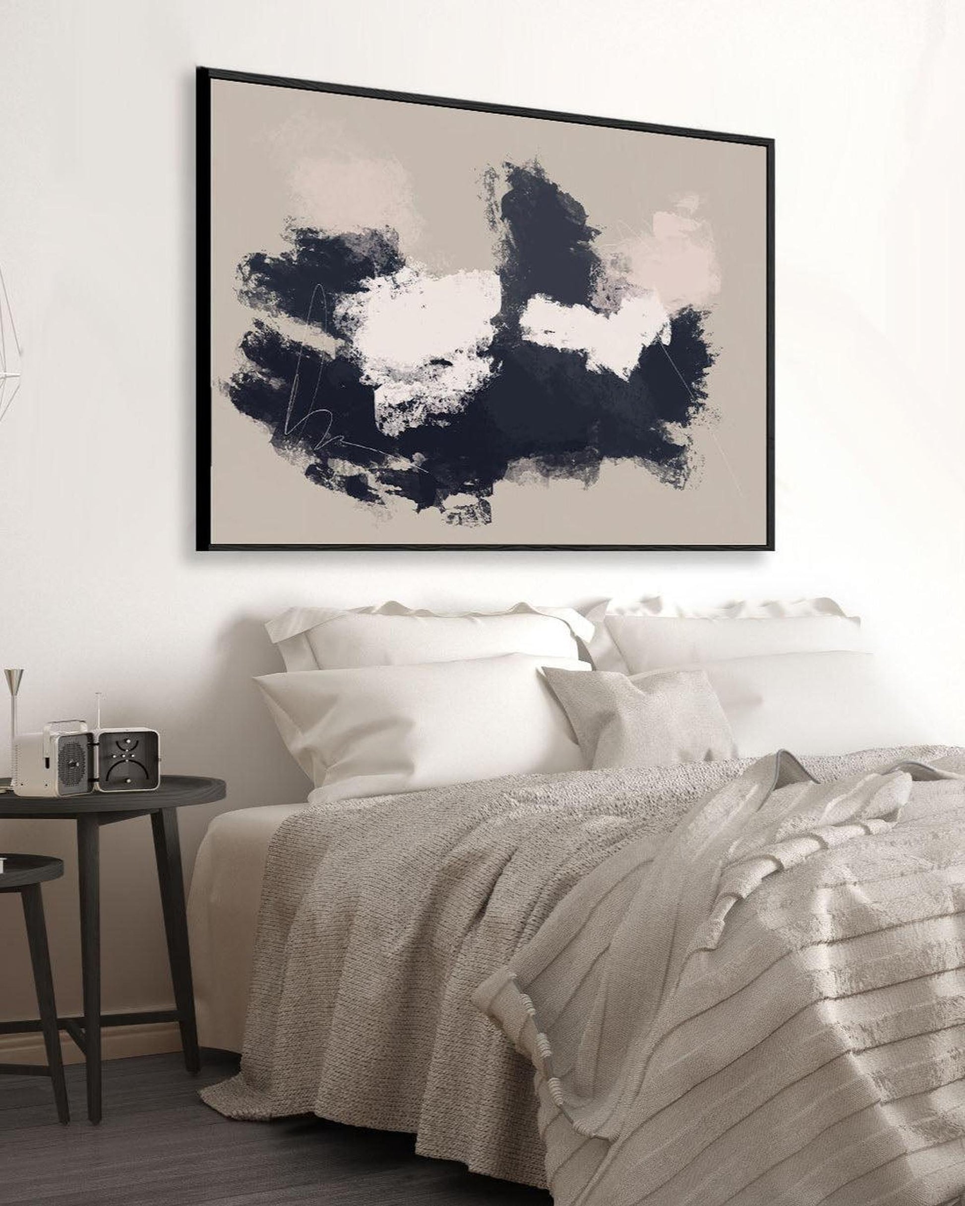 Abstract black and white painting above a bed in a bedroom setting