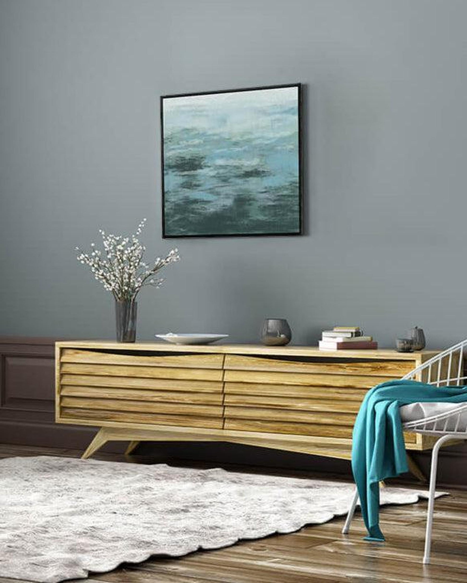 Living room with wooden console table, decorative items, and abstract painting on gray wall.