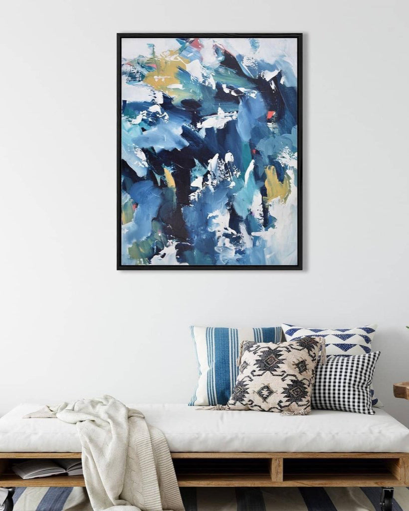 Abstract painting in a modern living room with a bench and decorative pillows.