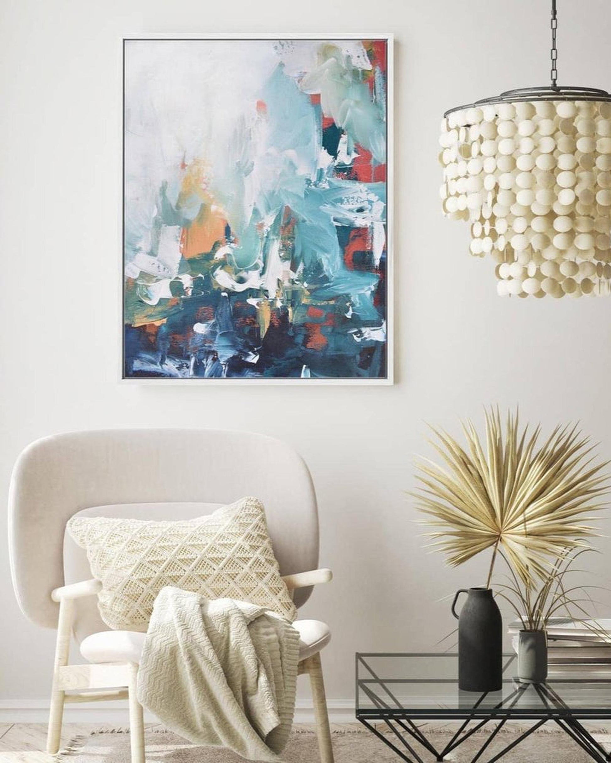 Modern living room with abstract art, chair, and decorative elements.