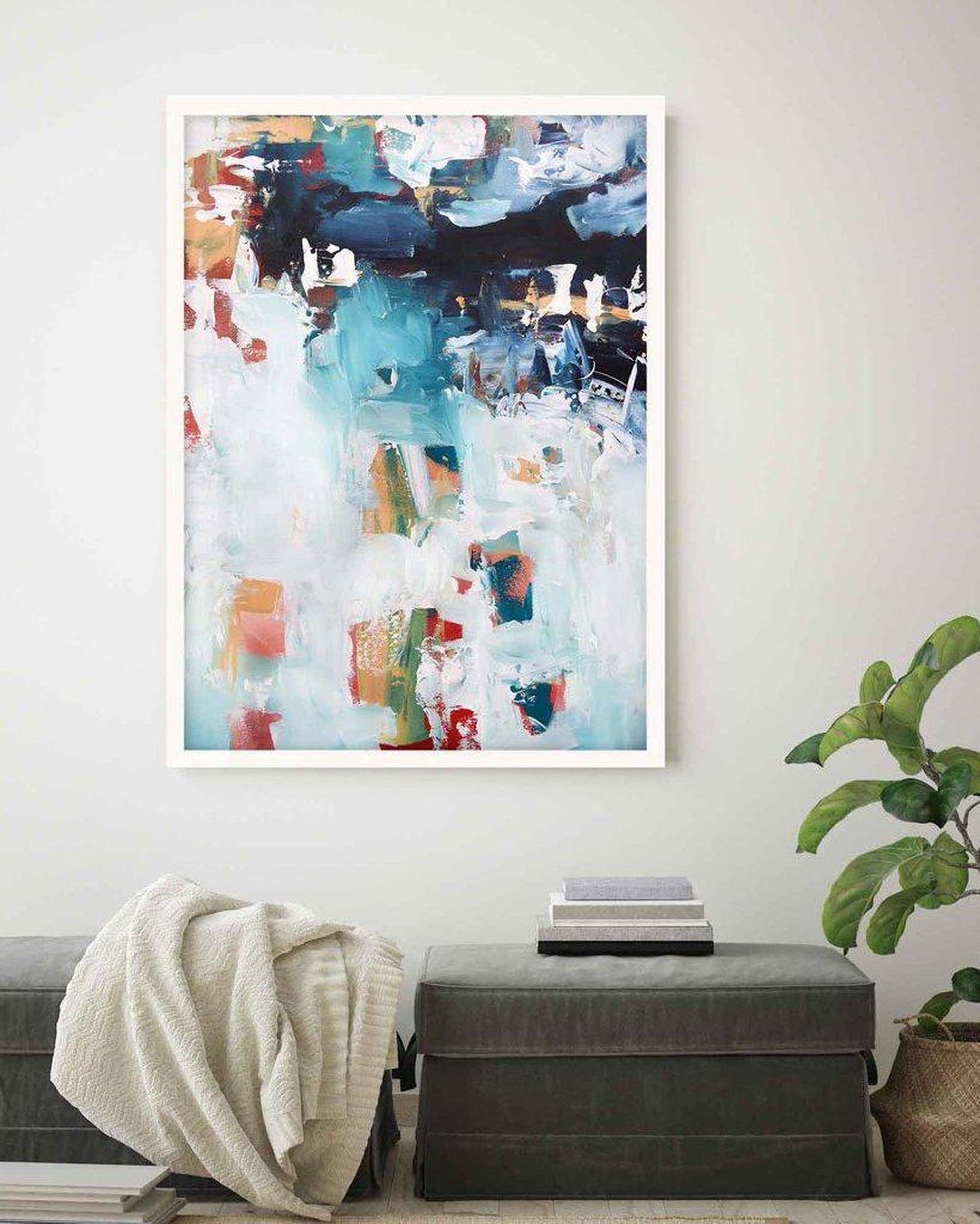 Abstract art print on a wall above a bench with a plant