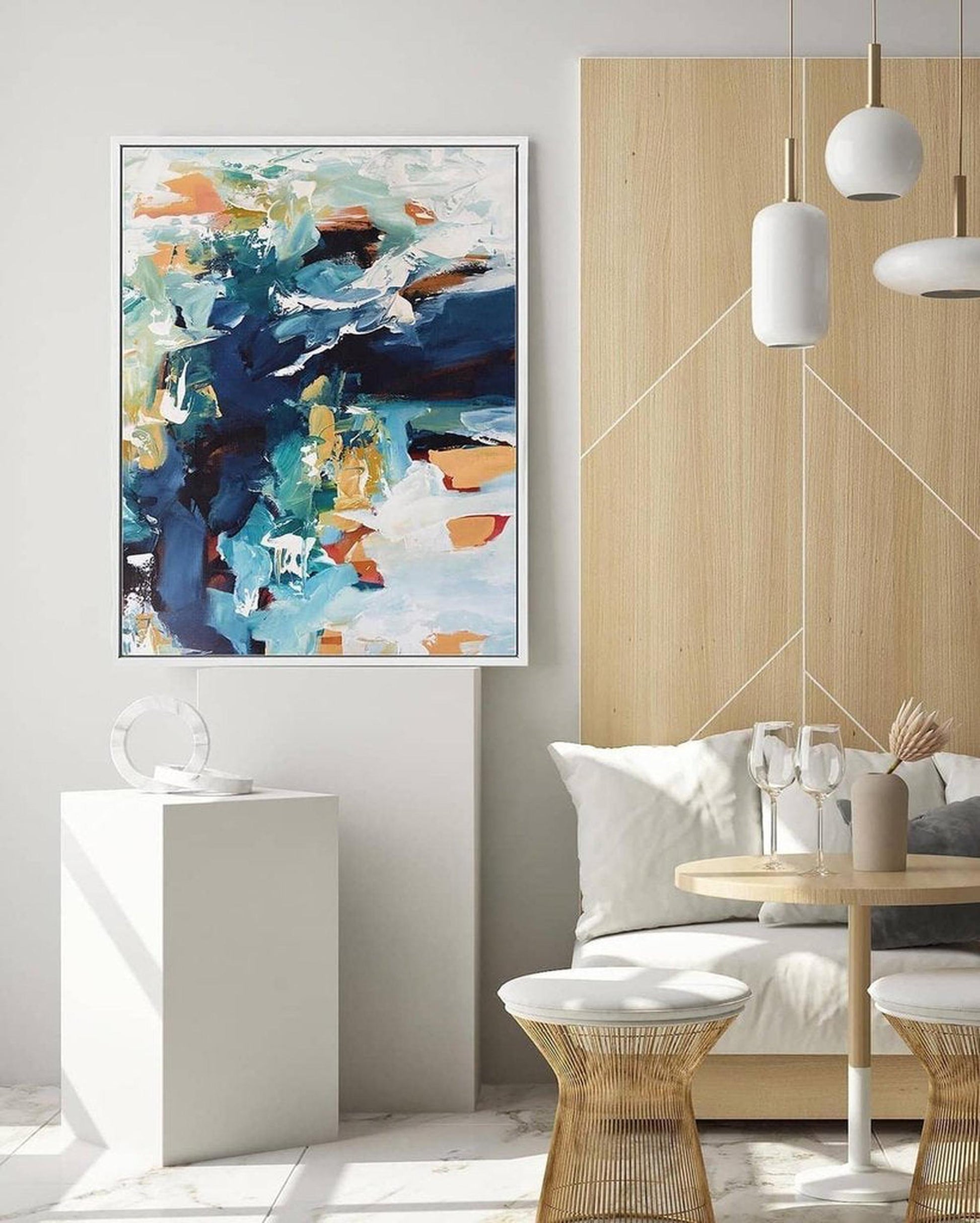 Modern living room with abstract art on the wall, white sofa, and decorative items.