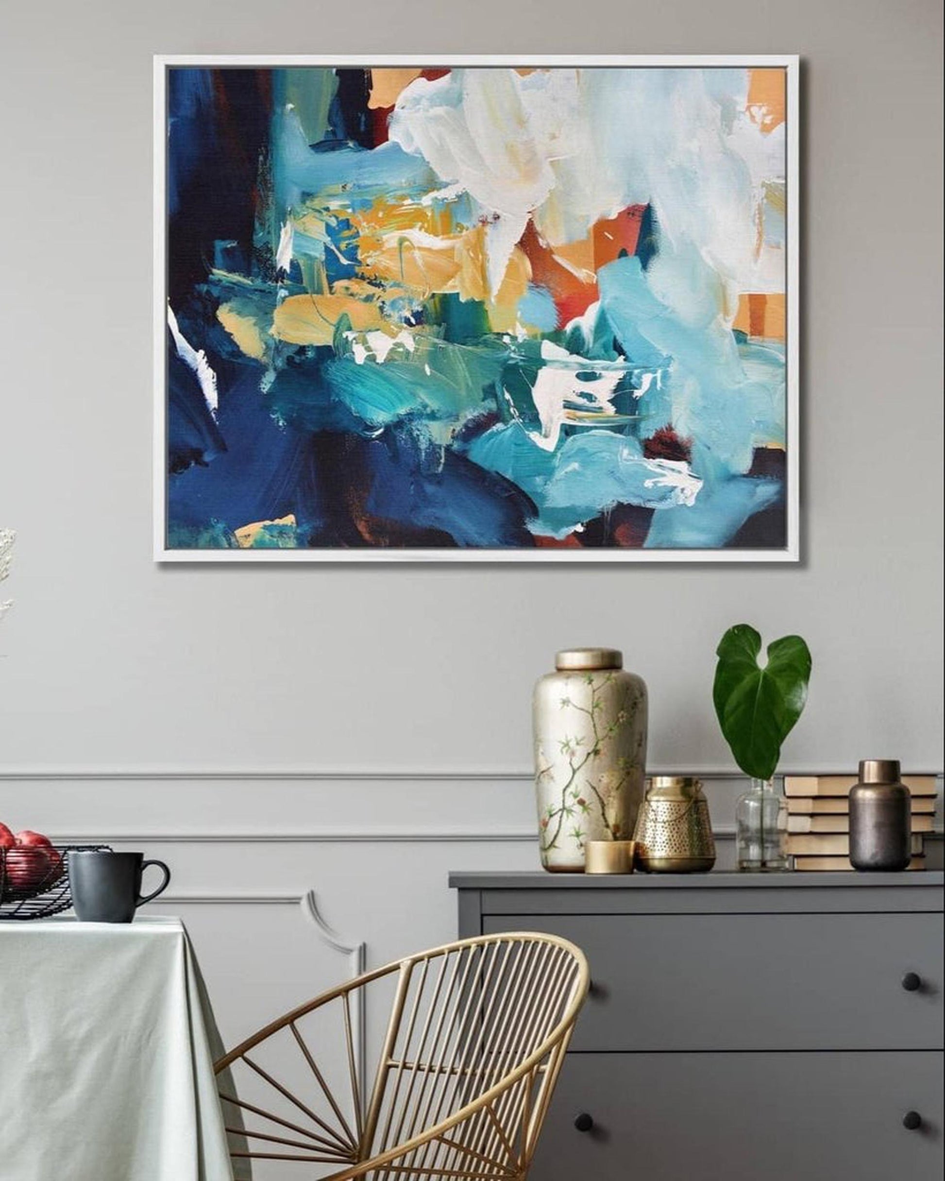 Abstract painting on a wall above a table with decorative items.