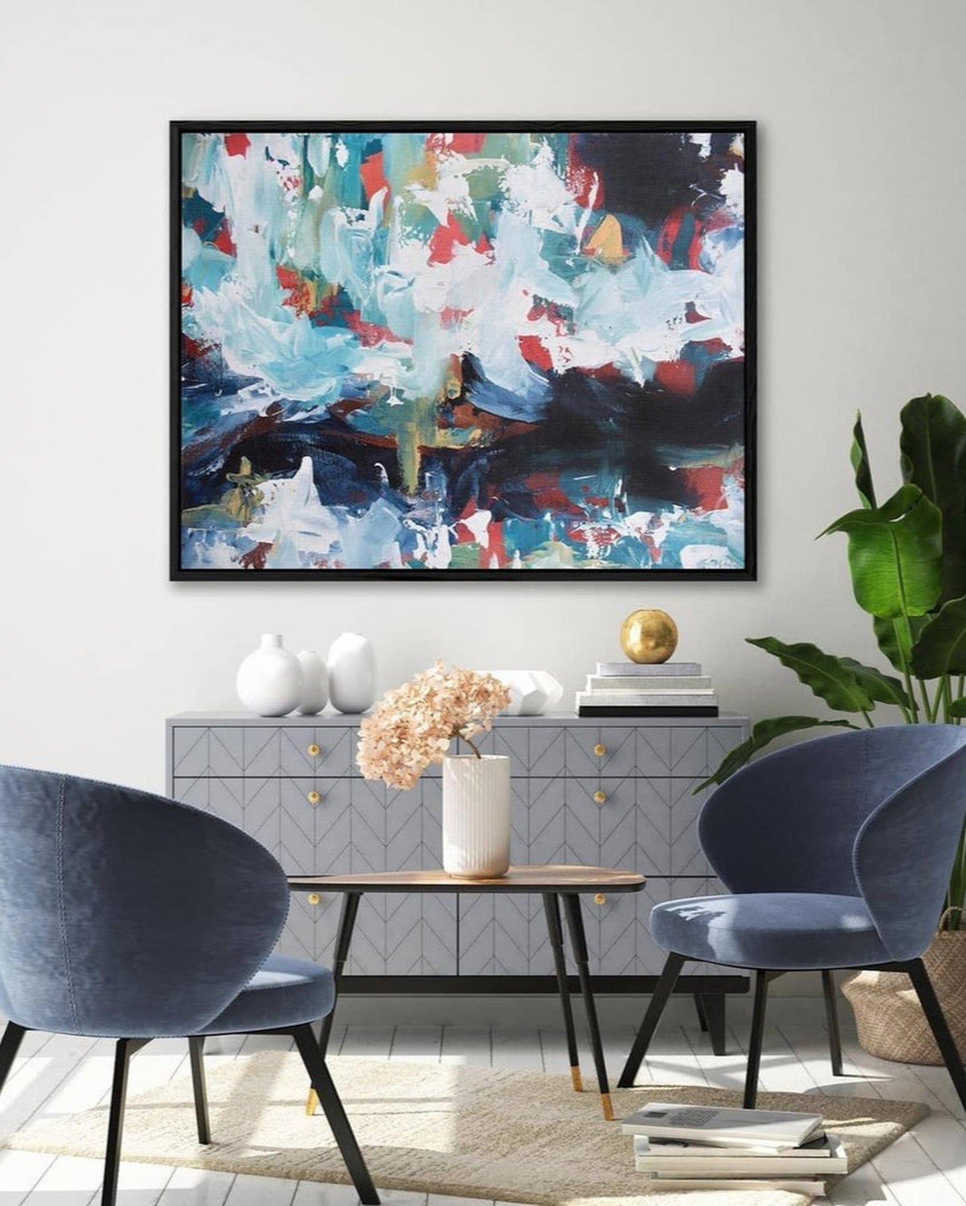 Modern living room with abstract art, blue chairs, and a side table.