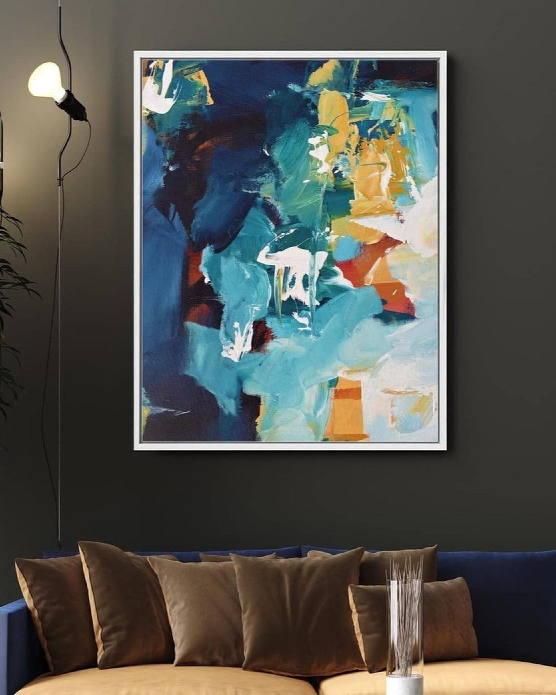 Abstract painting on a wall above a sofa with decorative pillows.