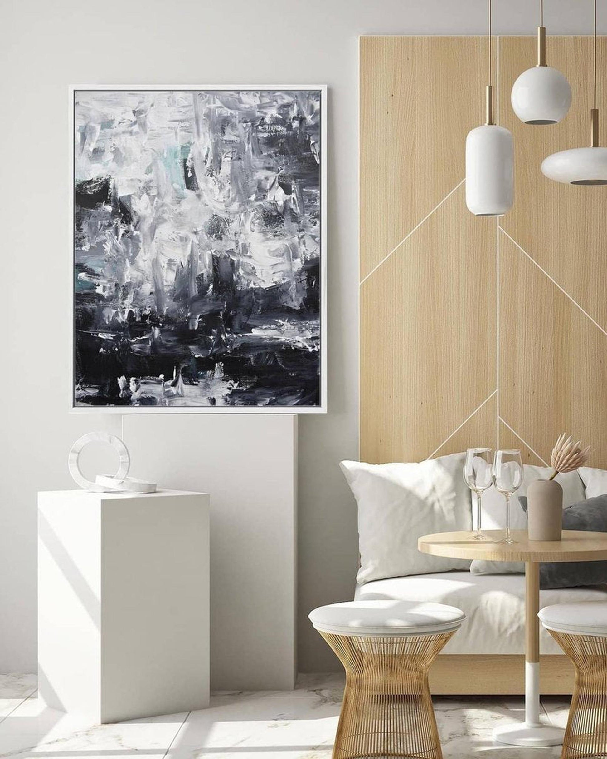 Modern living room with abstract art on the wall, white sofa, and wooden side table.