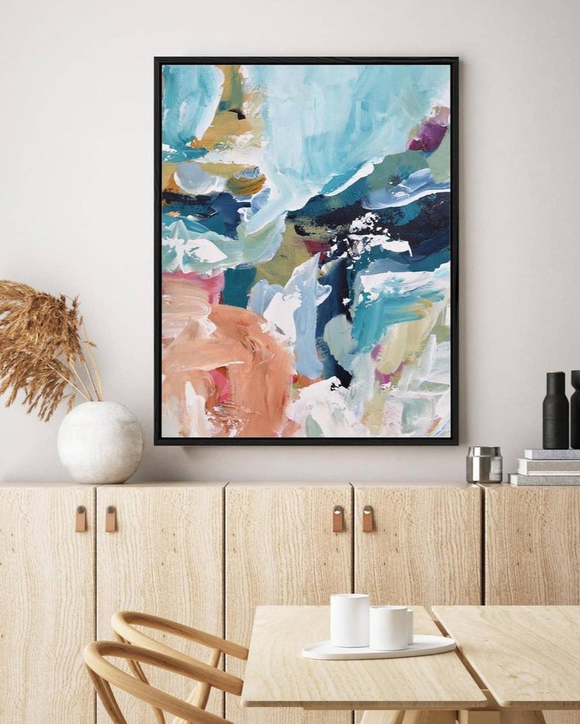 Abstract art print on a wall above a kitchen counter with decor items.