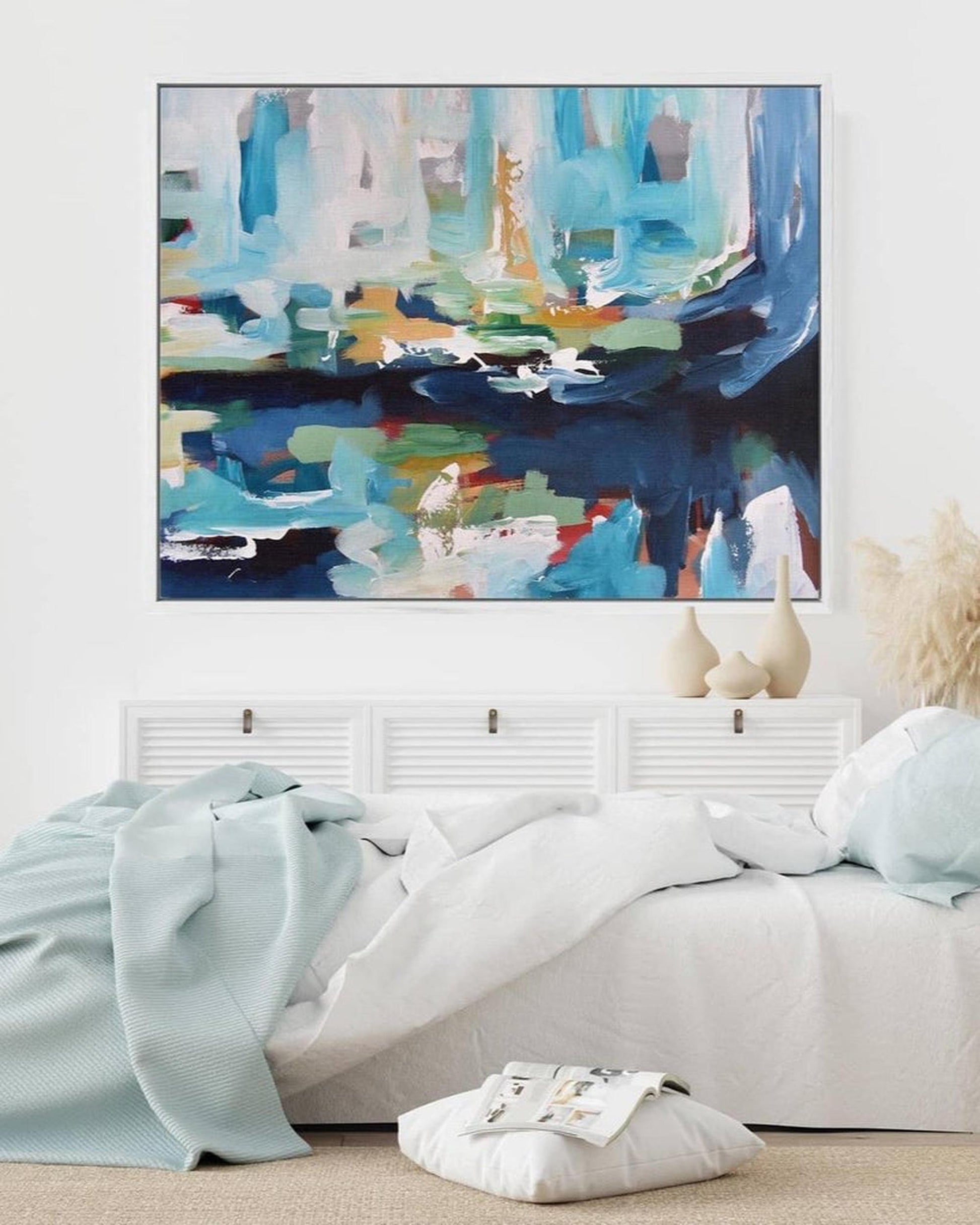 Abstract painting on a wall above a bed in a bedroom