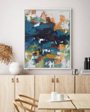 Abstract art piece on a wall above a wooden cabinet with a dining table.