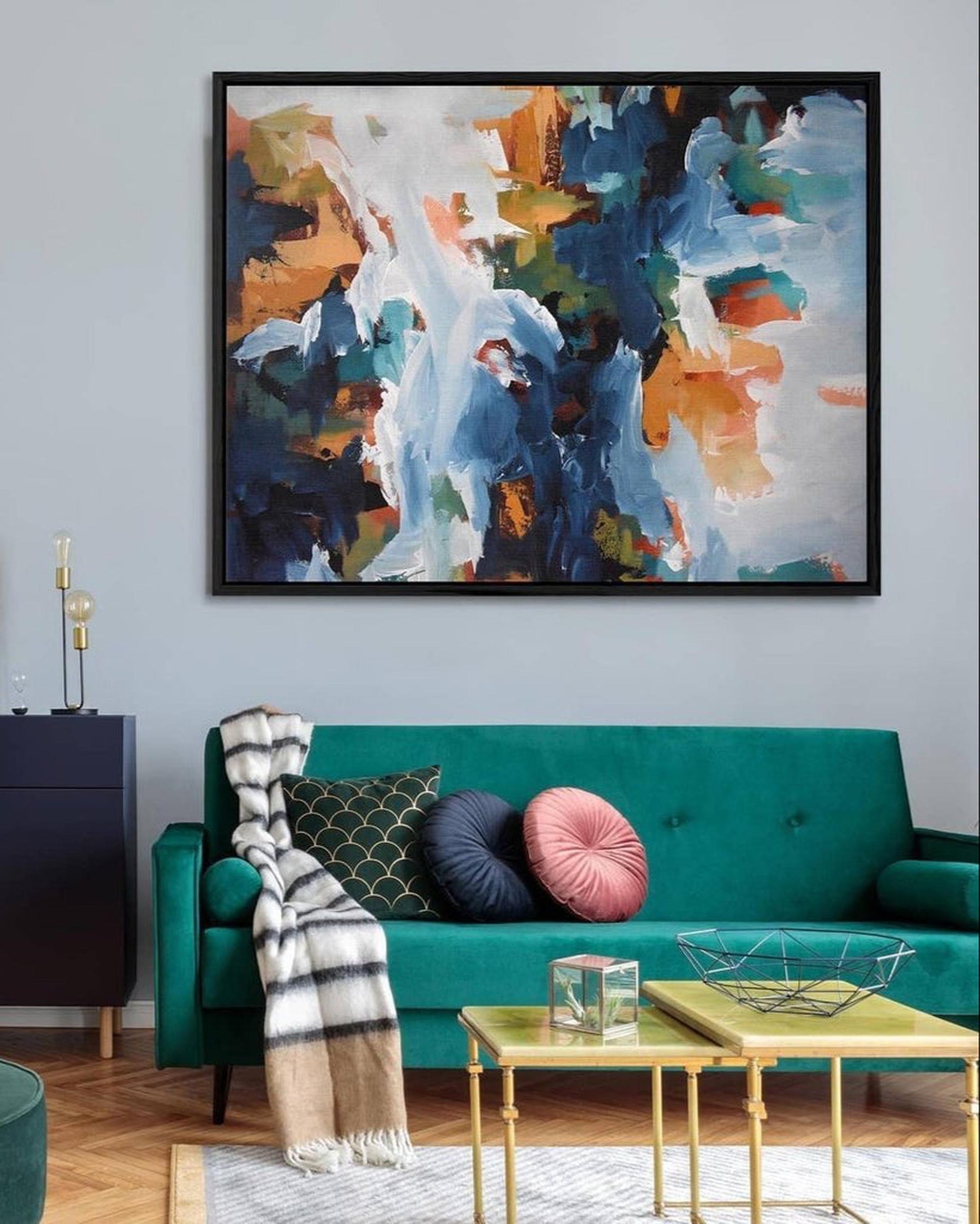 Living room with a teal sofa, colorful abstract painting, and decorative pillows.