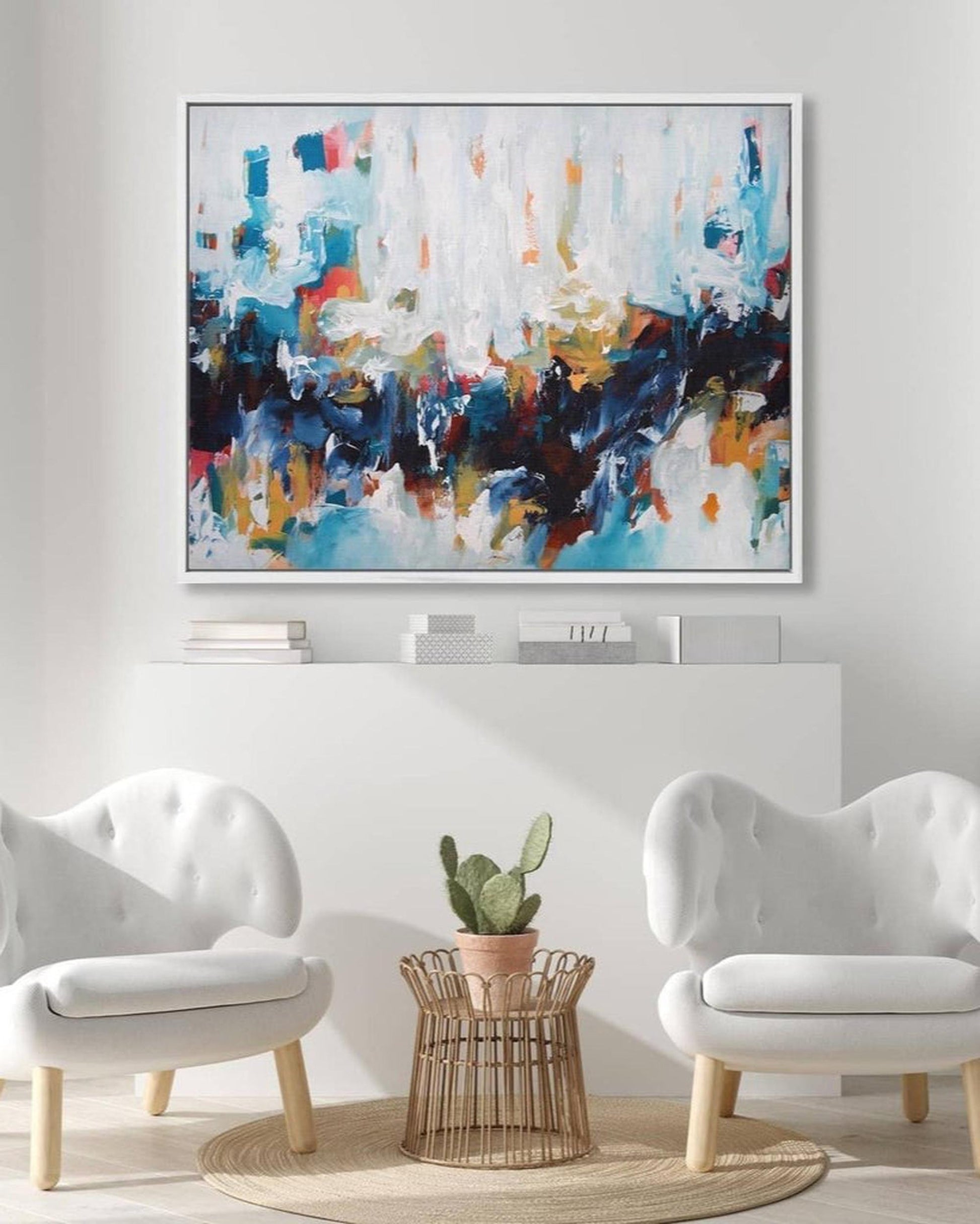 Abstract painting in a modern living room with white walls and furniture.