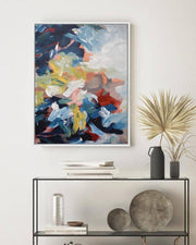 Abstract painting on a wall above a console table with decorative items.