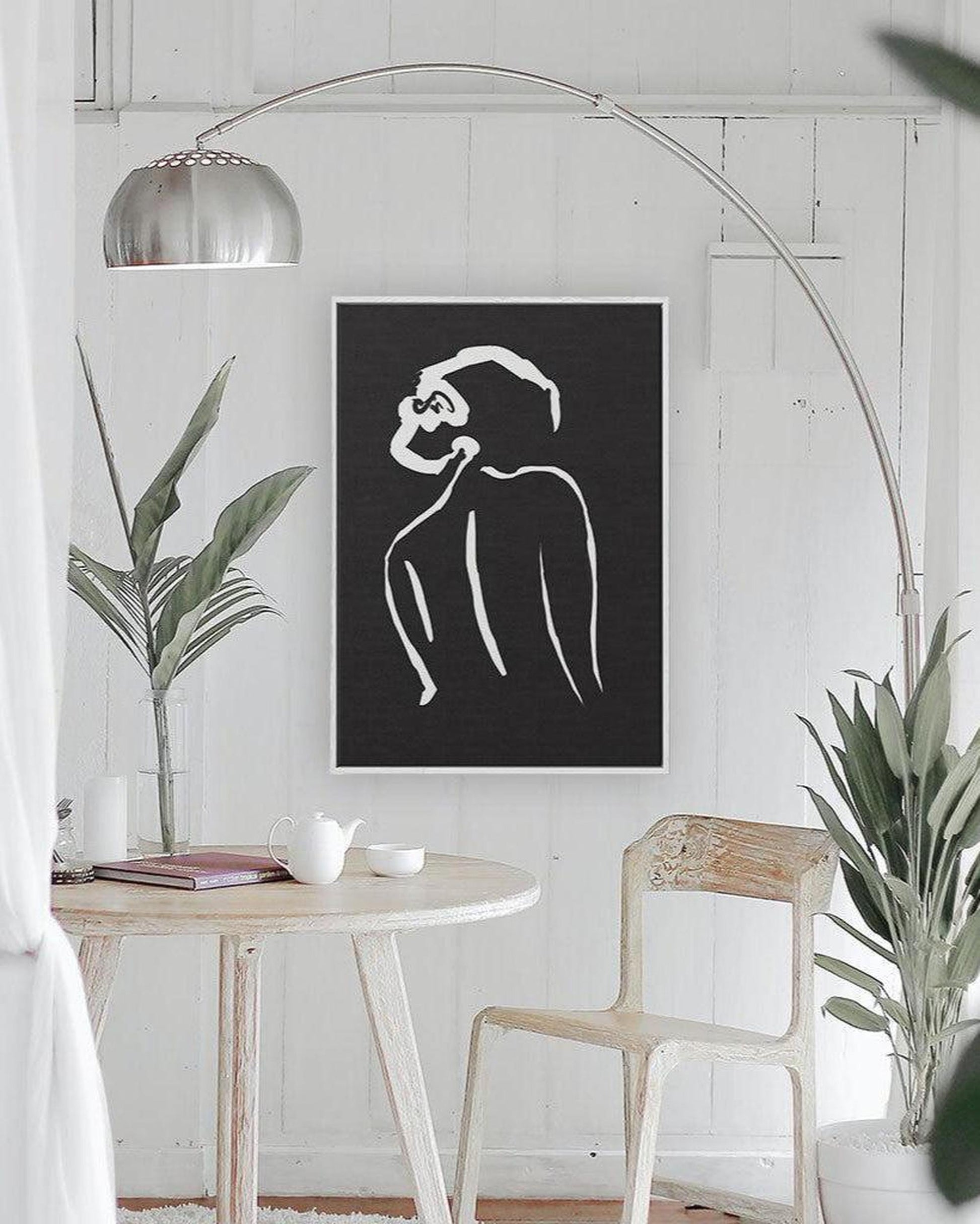 Modern interior with a black and white abstract art print on a white wall.
