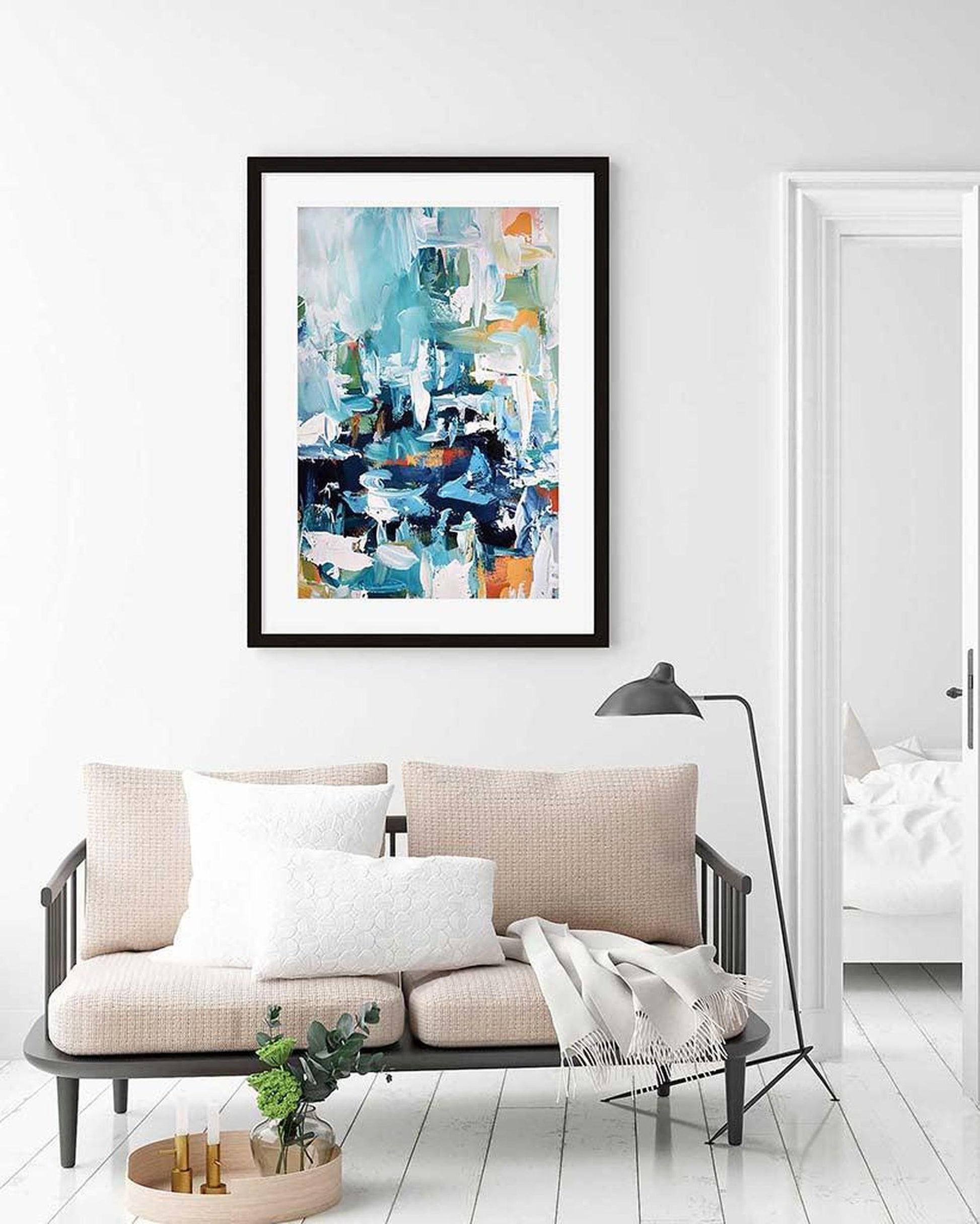 Framed abstract art piece on a wall above a sofa in a modern living room.
