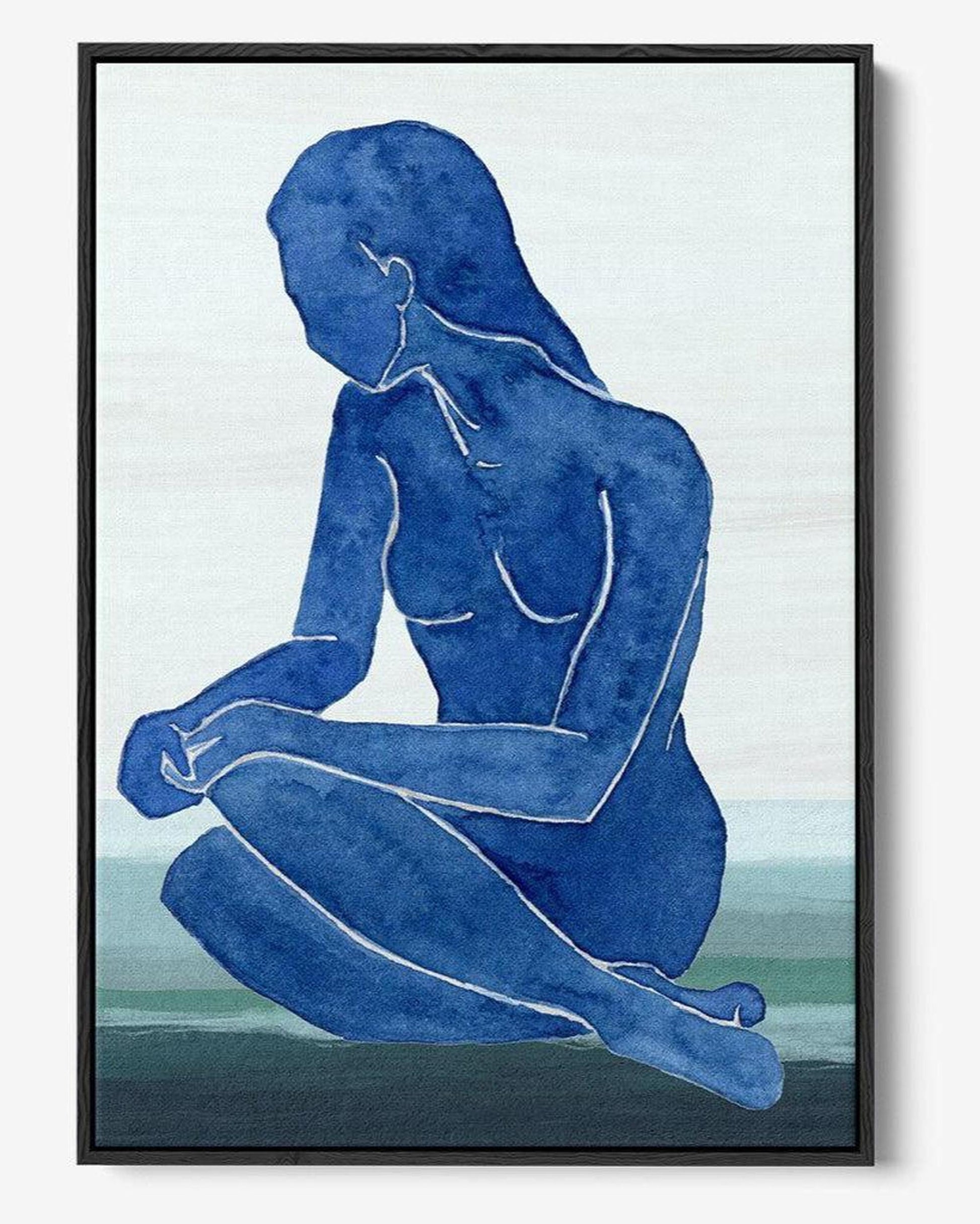 Framed artwork of a blue silhouette of a nude figure sitting on a landscape.