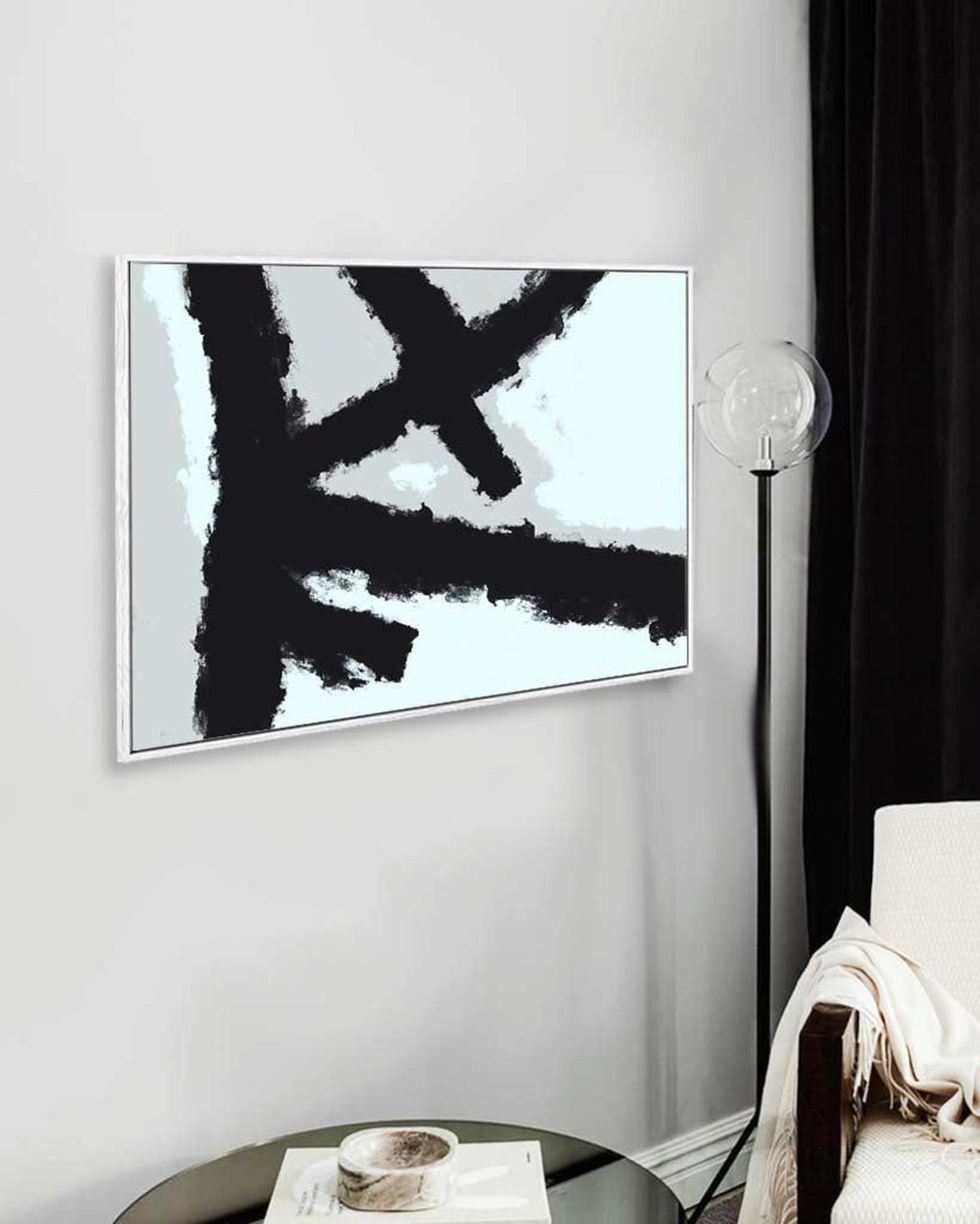 Abstract black and white painting on a wall in a modern interior setting.