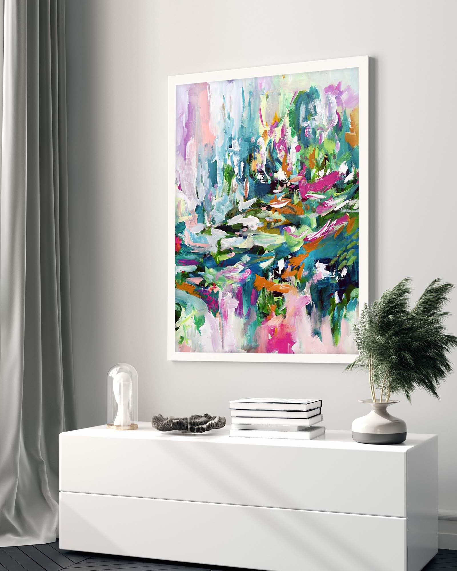 Colourful abstract painting on a wall above a white console table with decorative items.
