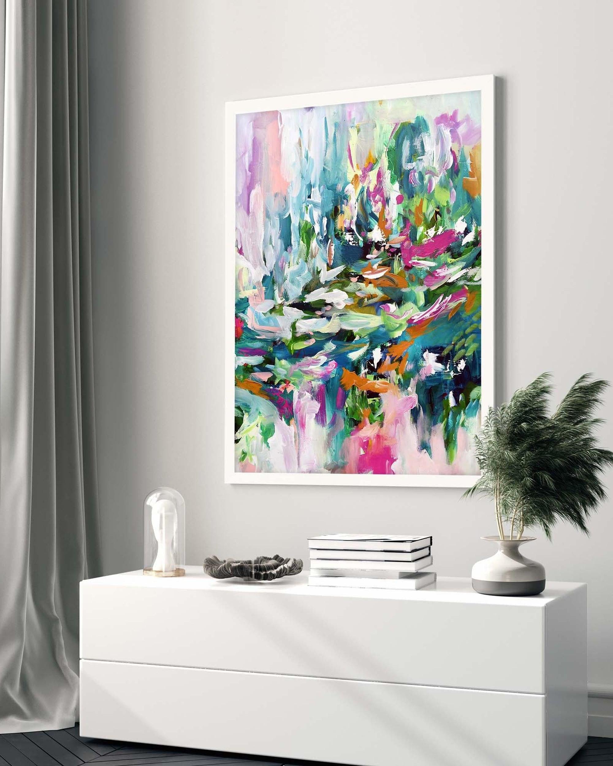 Colourful abstract painting on a wall above a white console table with decorative items.