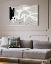Gray sofa with a decorative pillow in a living room setting, featuring an abstract painting on the wall.