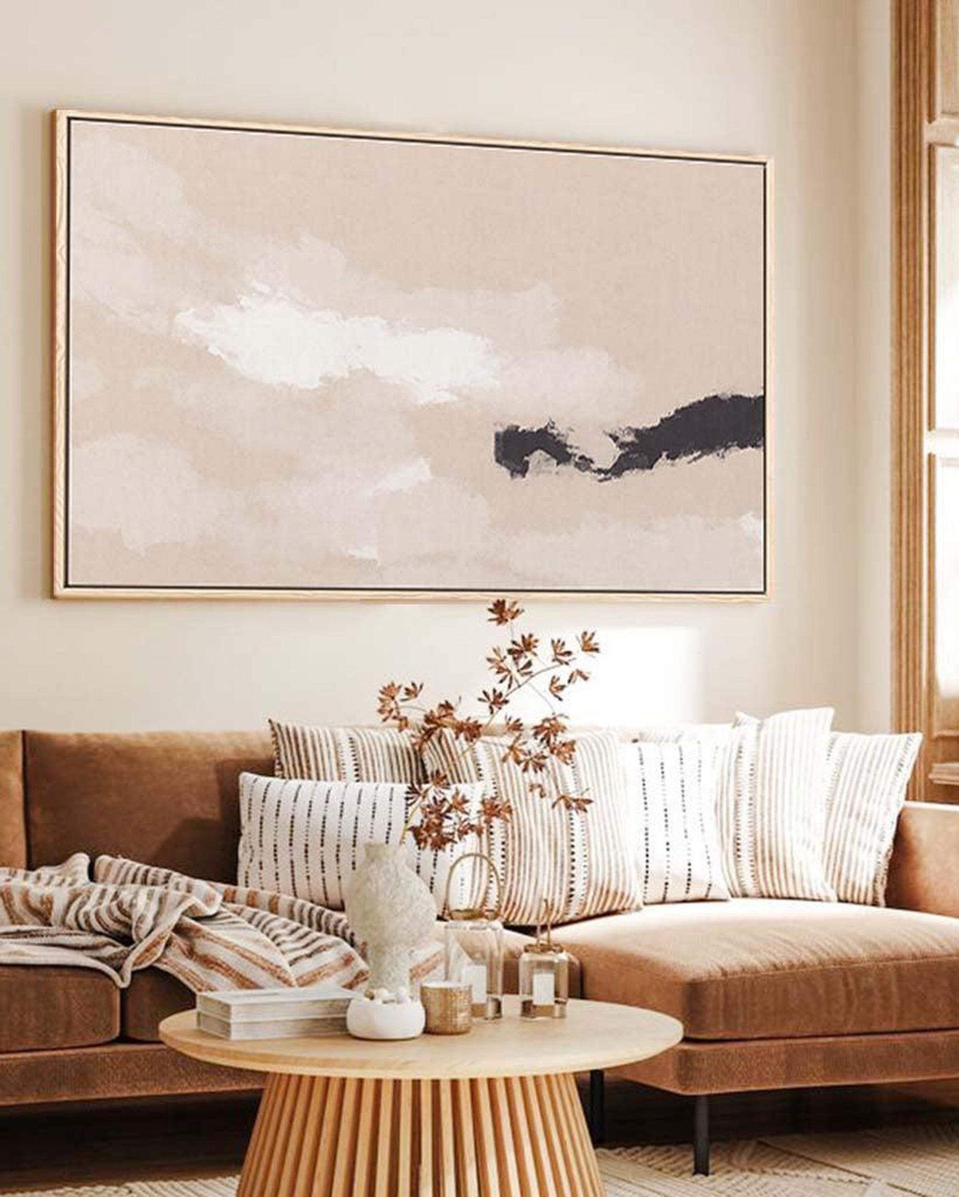 Living room with a brown sectional sofa, wooden coffee table, and abstract wall art.