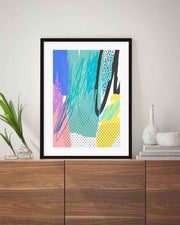 Framed abstract art print on a wooden cabinet with decorative items.
