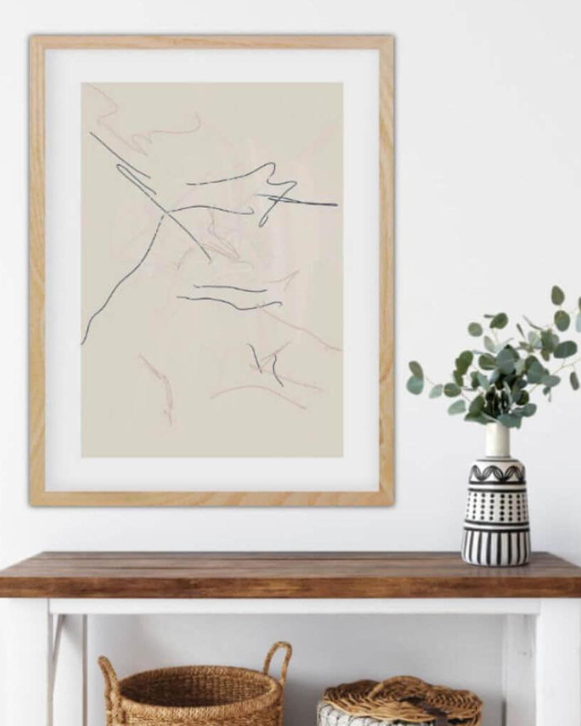Framed abstract artwork on a wall above a wooden console table with decorative items.