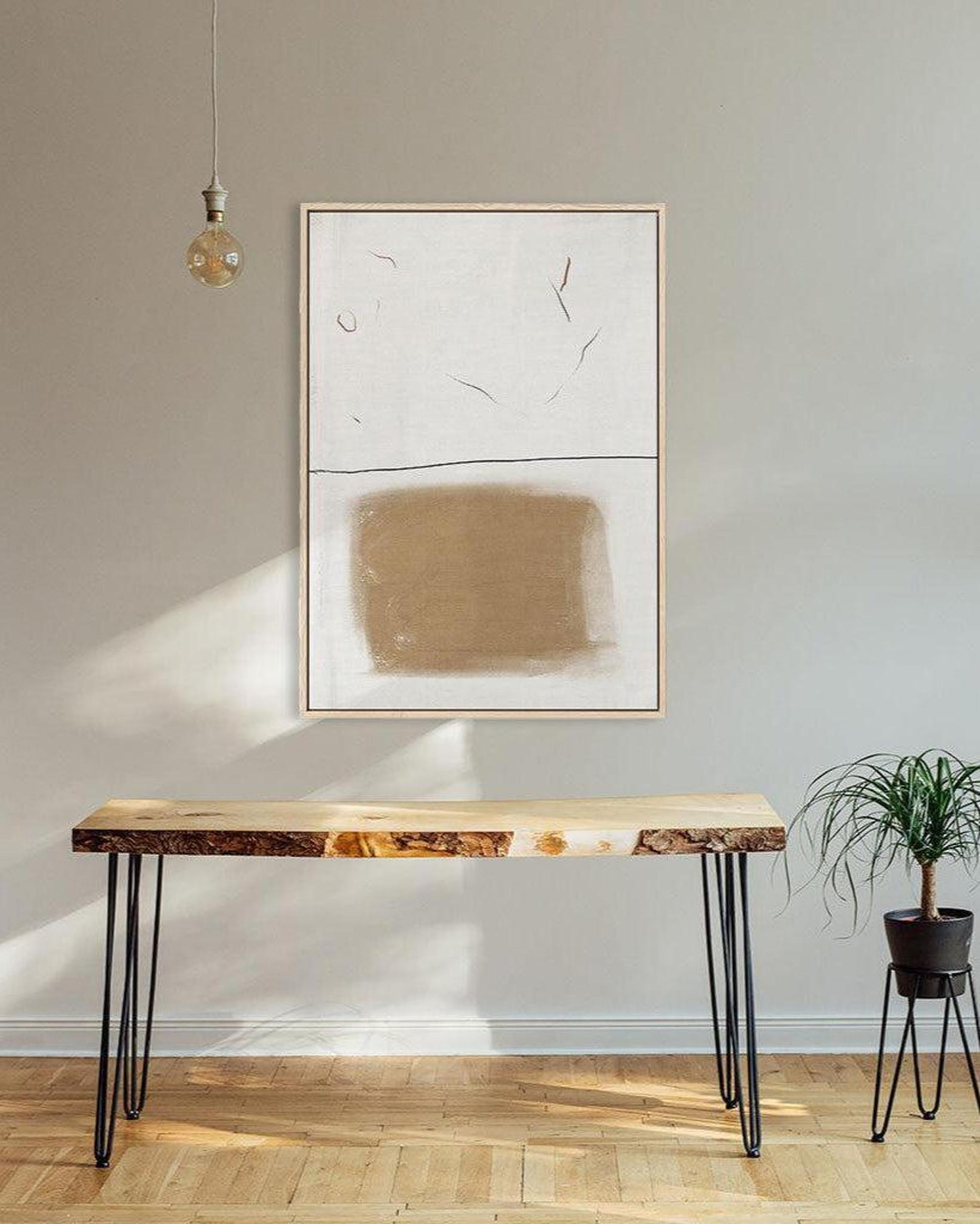 Modern interior with a wooden bench, abstract art, and a plant.
