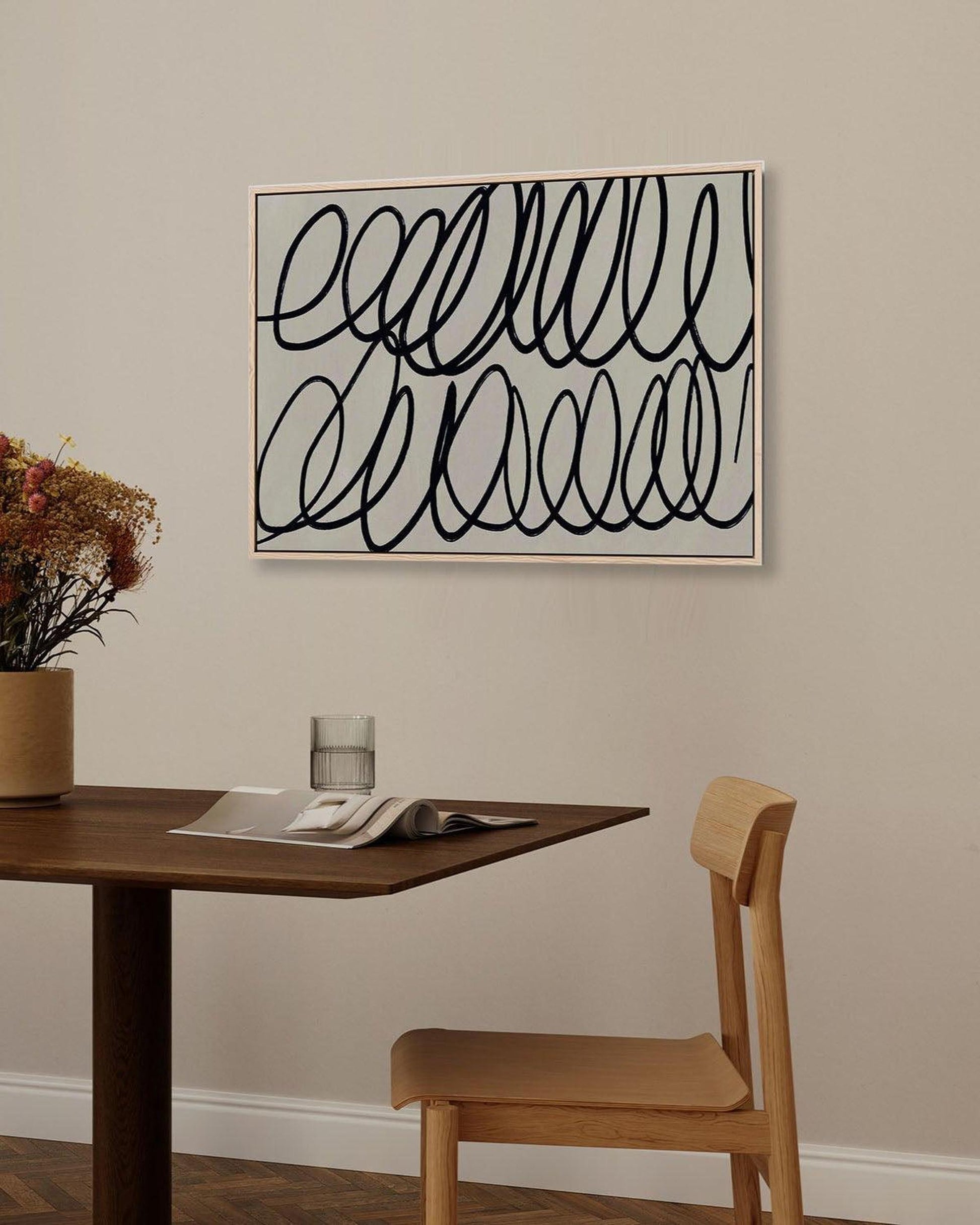 Dining room with a table, chair, and abstract art on the wall.