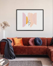 Living room with a brown sectional sofa, colorful cushions, and a framed abstract art piece on the wall.